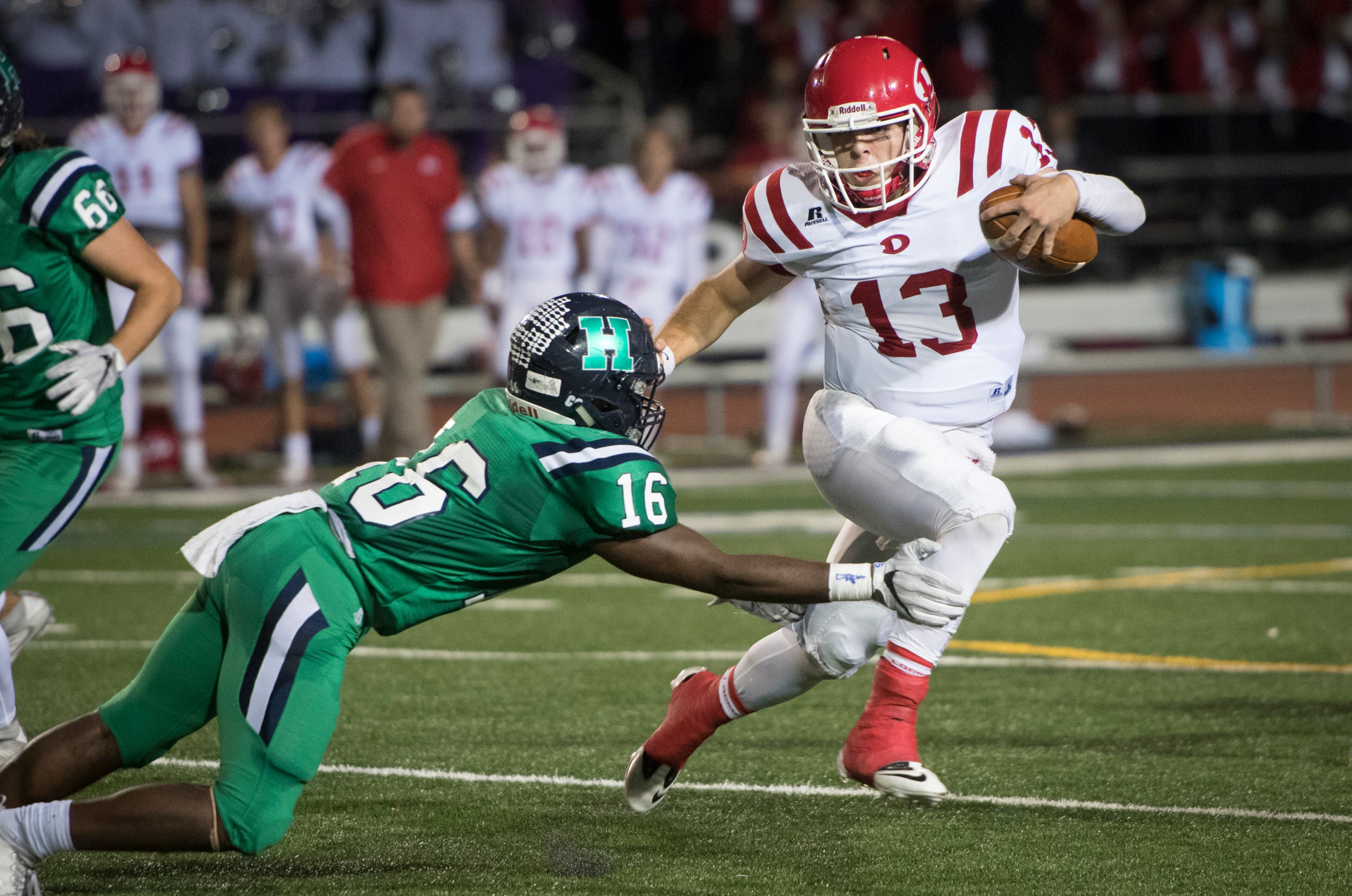 Dalton quarterback JP Tighe (13) runs as Harrison linebacker Kameron Coleman (16) tries to stop him during a high school football game on Thursday, Oct. 19, 2017, in Kennesaw, Ga. (Special to the Atlanta Journal-Constitution, John Amis )