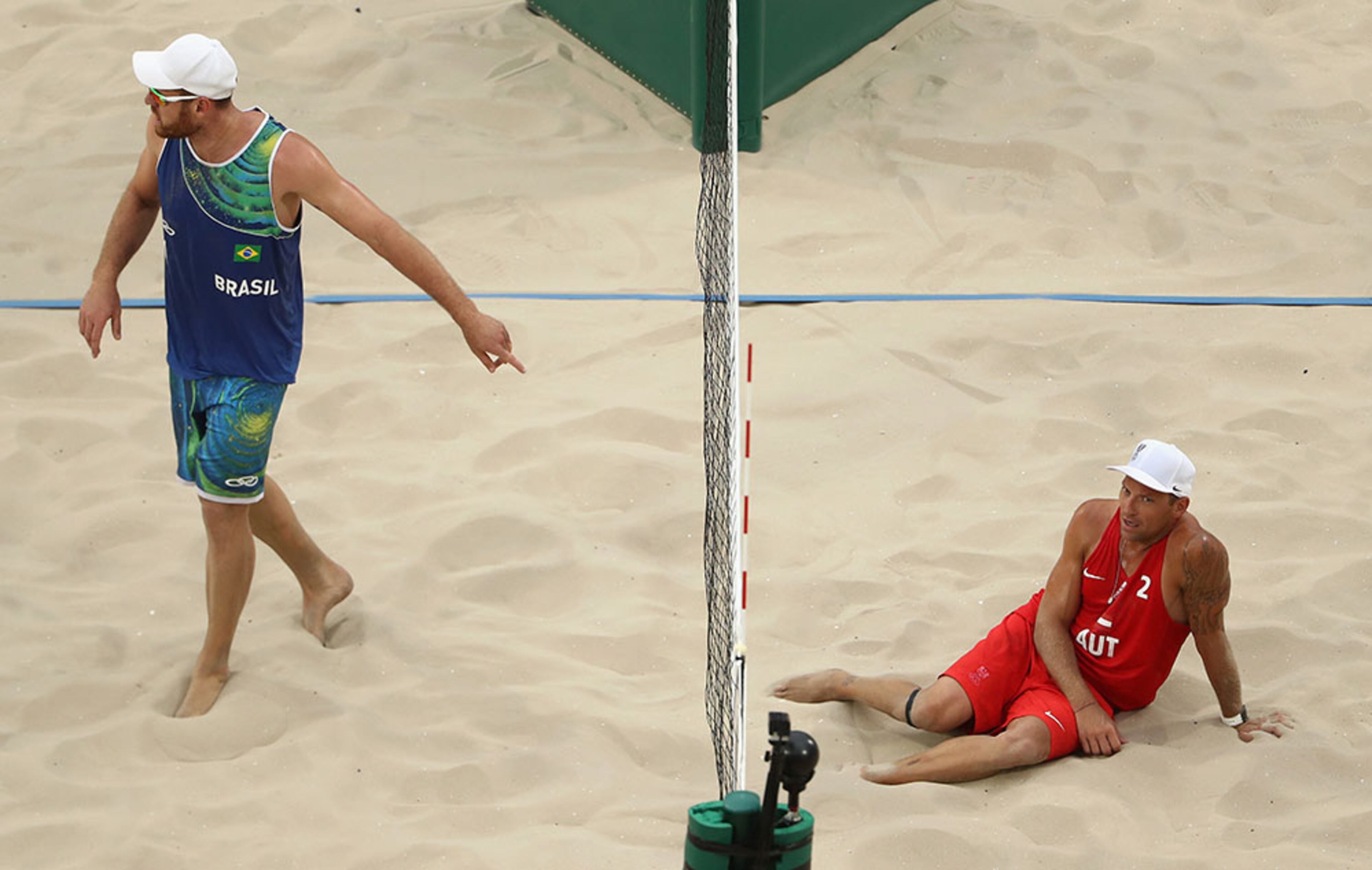 Alison Cerutti of Brazil and Alexander Horst of Austria react to a play during the Men's Beach Volleyball preliminary round Pool A match on Day 3 of the Rio 2016 Olympic Games at the Beach Volleyball Arena on Aug. 8, 2016 in Rio de Janeiro, Brazil.