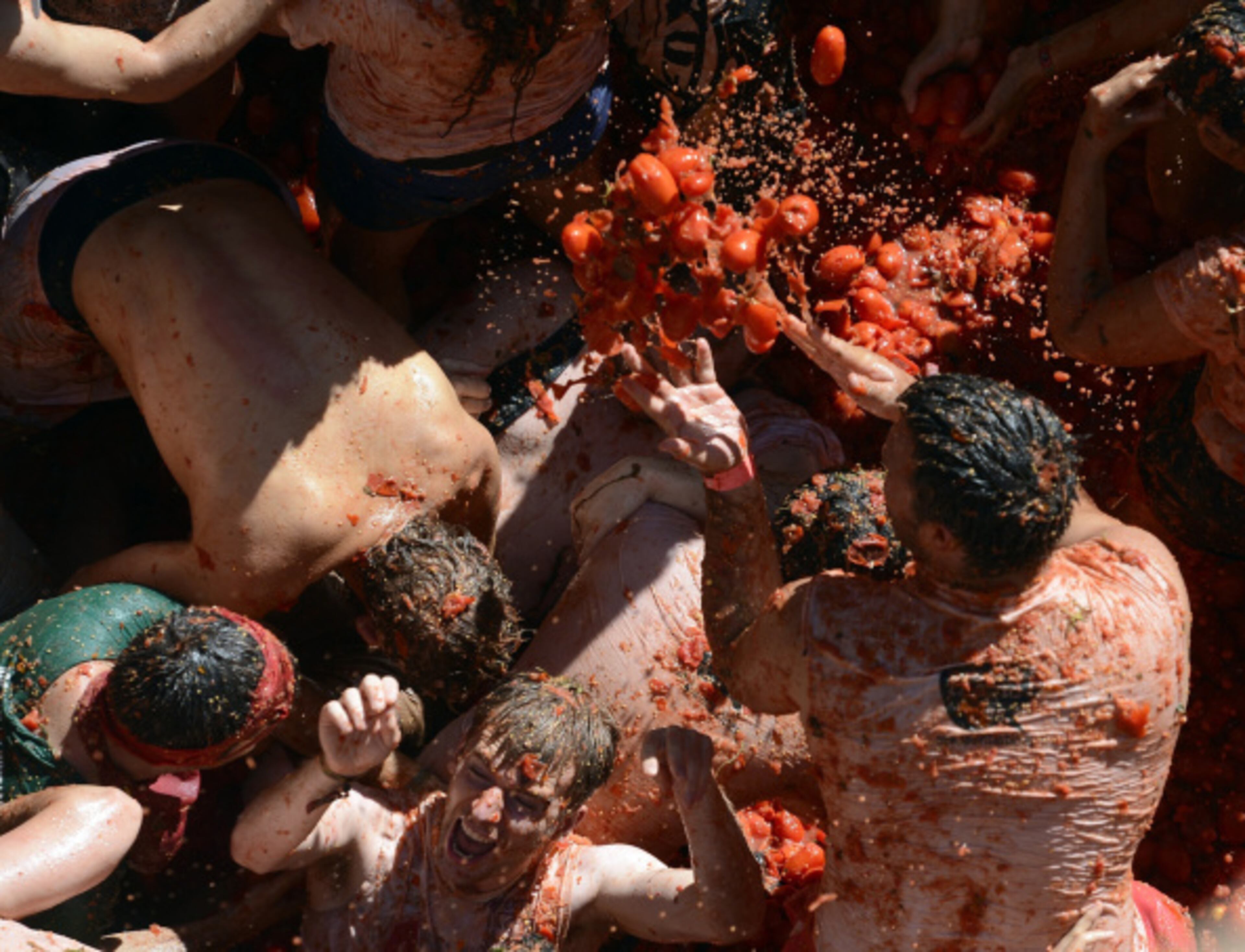 VALENCIA, SPAIN - AUGUST 27: Revellers throw tomatoes while participating the annual La Tomatina festival on August 27, 2014 in Bunol district of Valencia, Spain. (Photo by Evrim Aydin/Anadolu Agency/Getty Images)