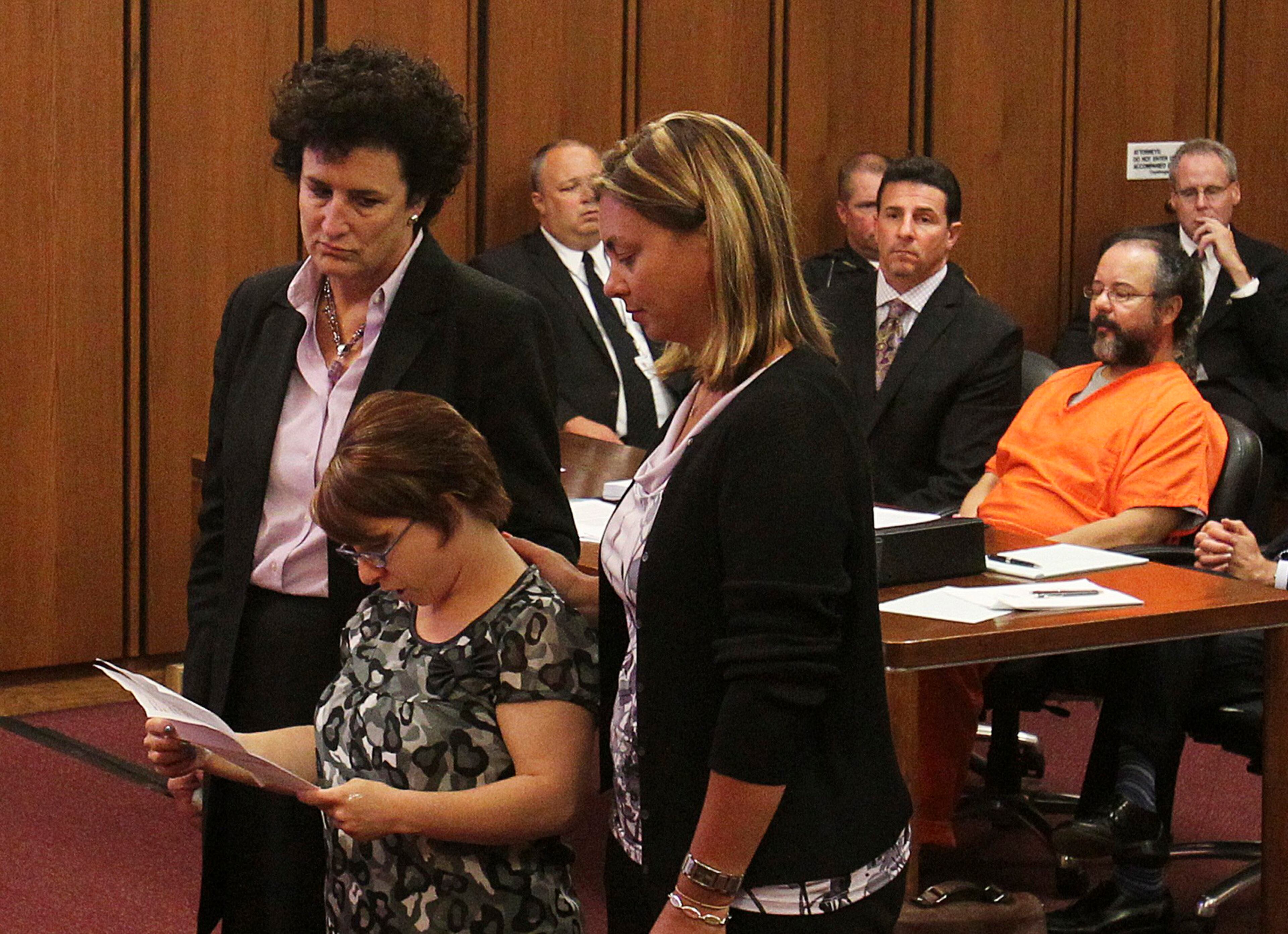 Michelle Knight (2nd L) reads statements while supported by her attorney (L) and a friend as her accused assailant Ariel Castro (R) sits in the courtroom during Castro's sentencing of kidnapping, rape and murder in Cleveland, Ohio in this August 1, 2013 file photo. Castro, the Cleveland man sentenced to life in prison for the abduction, rape and torture of three women, was found dead in his Ohio jail cell, according to a prison official on September 3, 2013. REUTERS/Aaron Josefczyk/Files
