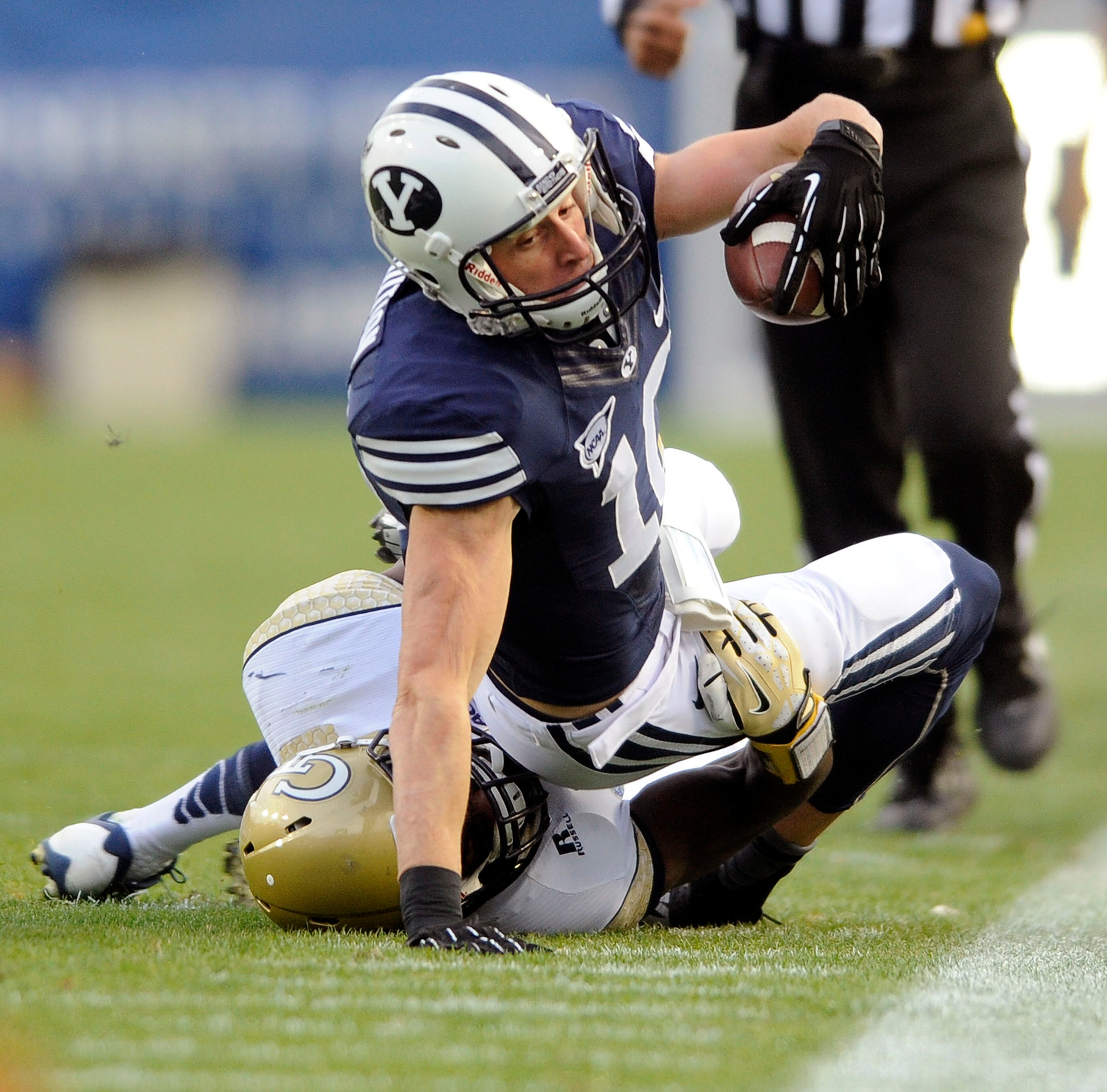 Brigham Young wide receiver Mitch Mathews (10) stretches out for yardage along the sidelines while being brought down by Georgia Tech defensive back Jemea Thomas (14) during an NCAA college football game, Saturday, Oct. 12, 2013 in Provo, Utah.