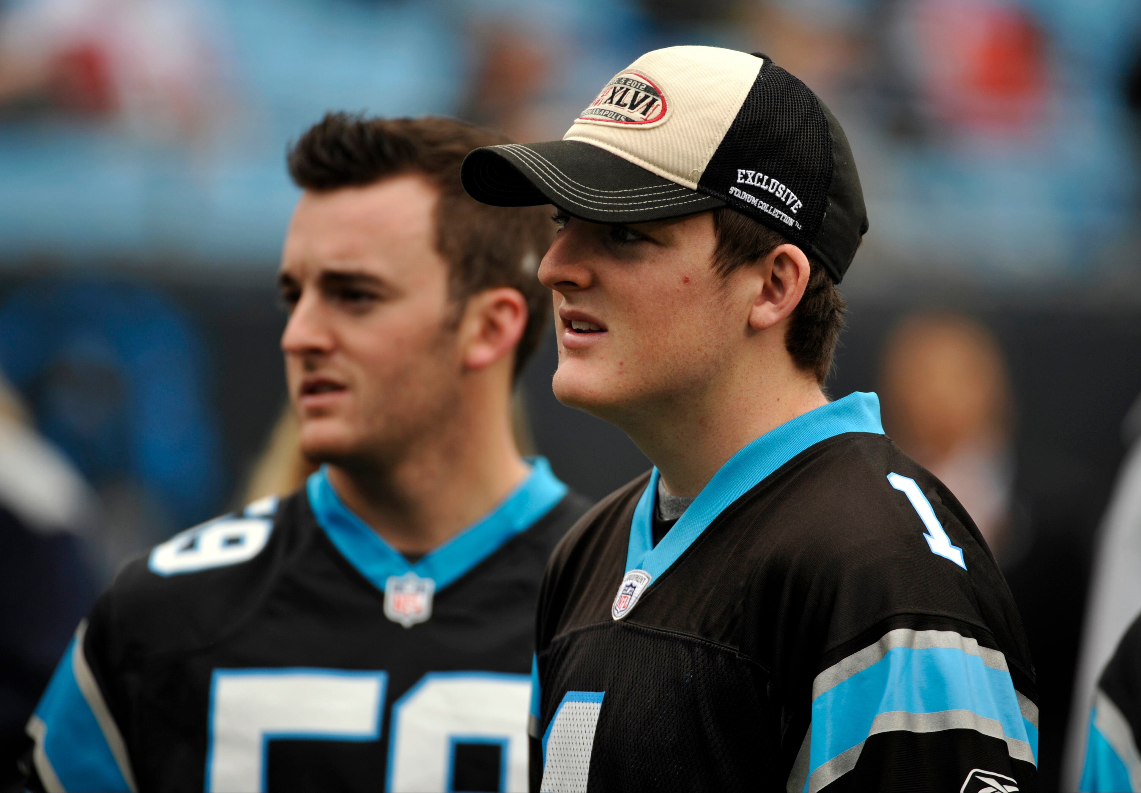 NASCAR drivers Ty Dillon, right, and Austin Dillon, left, watch teams warm up before an NFL football game between the Carolina Panthers and the Atlanta Falcons in Charlotte, N.C., Sunday, Dec. 9, 2012.