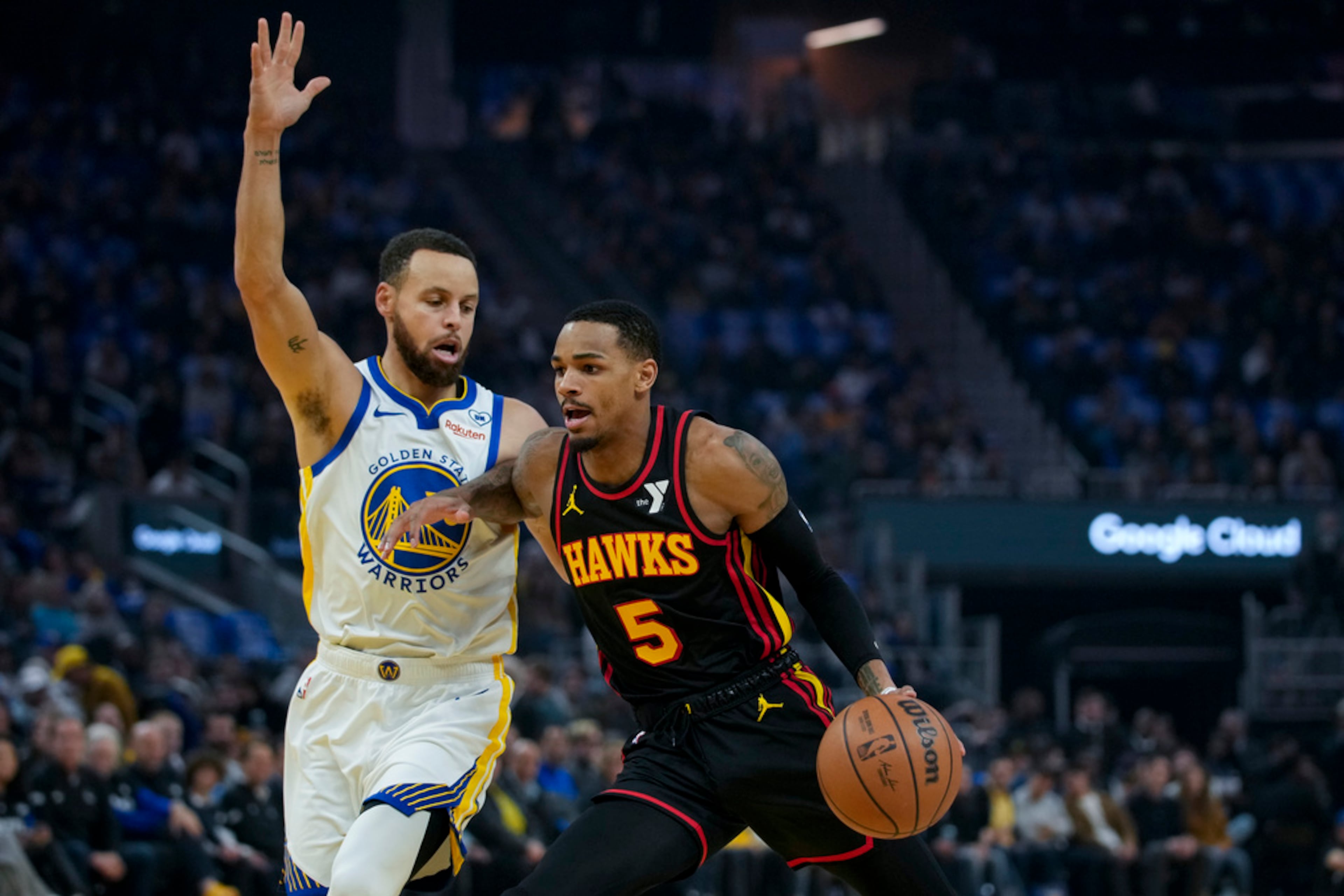 Atlanta Hawks guard Dejounte Murray, right, moves the ball while defended by Golden State Warriors guard Stephen Curry during the first half of an NBA basketball game, Wednesday, Jan. 24, 2024, in San Francisco. (AP Photo/Godofredo A. Vásquez)