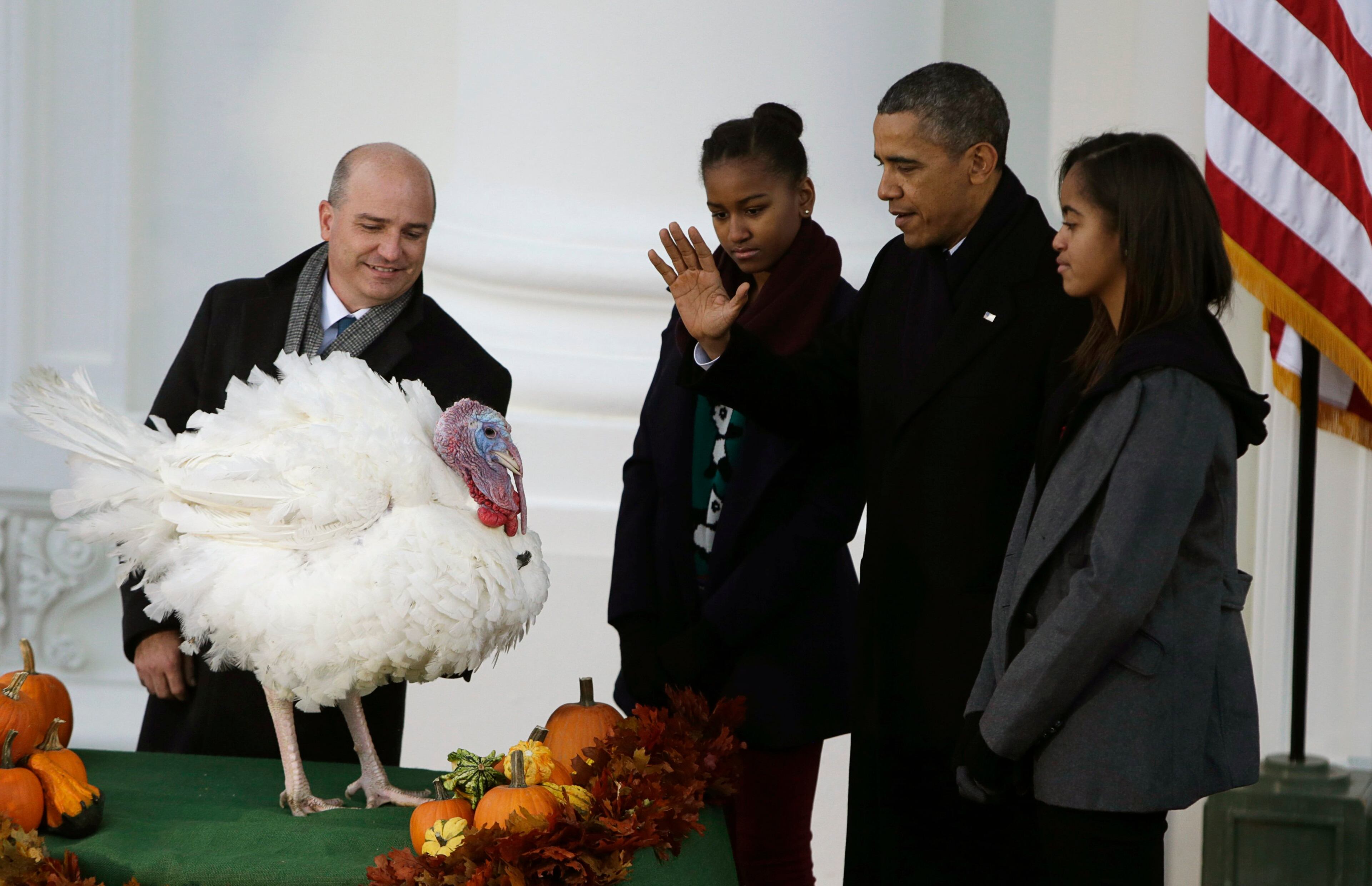 President Barack Obama gives the annual presidential pardon to the national Thanksgiving turkey at the White House in Washington on Nov. 27, 2013. John Burkel (left), chairman of the National Turkey Federation, and the president's daughters Malia (right) and Sasha (center) are pictured watching the pardon.