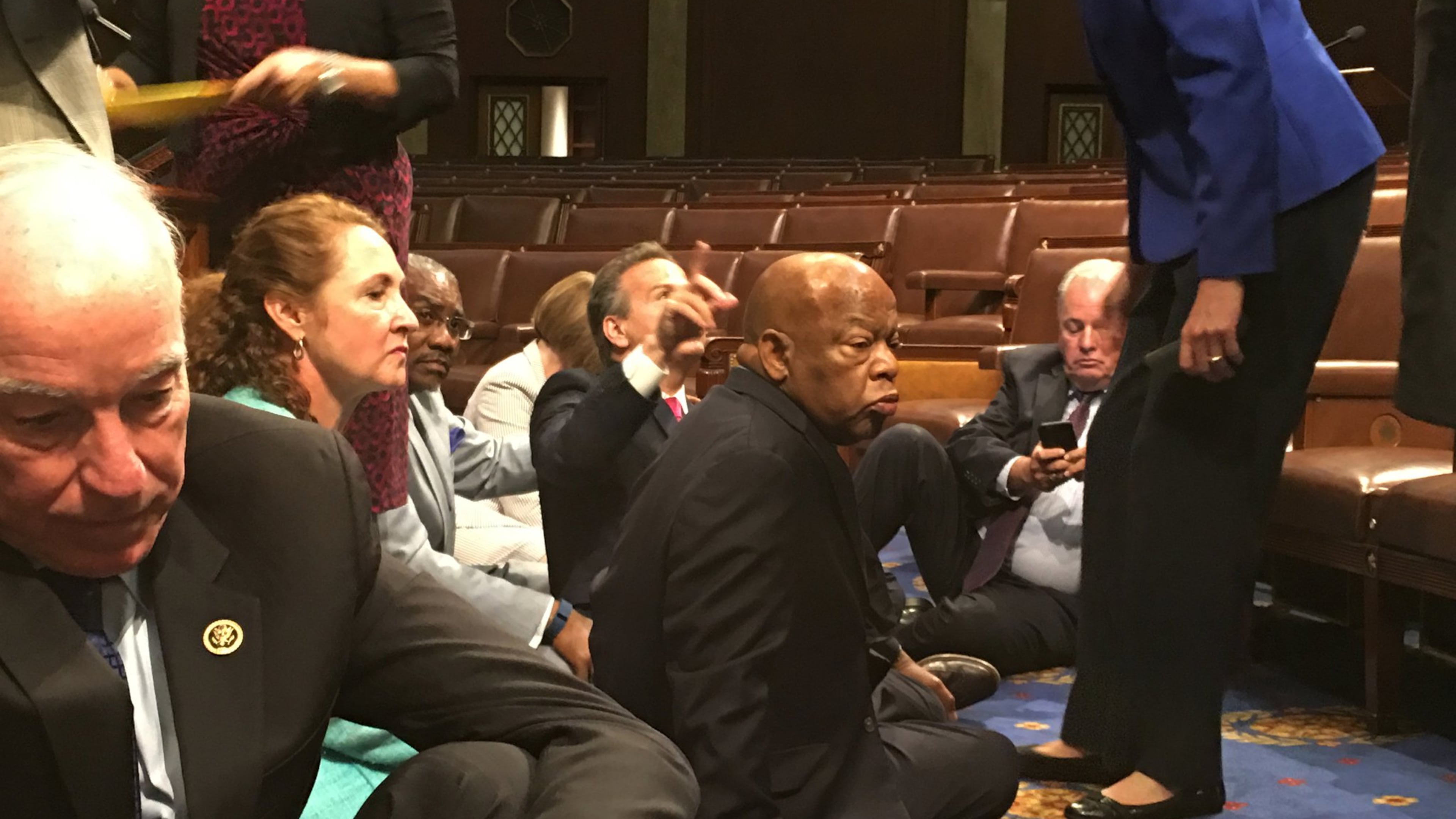 In this photo provided by Rep. John Yarmuth, D-Ky., Democratic members of Congress, including Rep. John Lewis, D-Ga., center, and Rep. Joe Courtney, D-Conn., left, participate in sit-in protest on the floor of the House on Capitol Hill in Washington on Wednesday, June 22, 2016 seeking a vote on gun control measures. (Rep. John Yarmuth via AP)