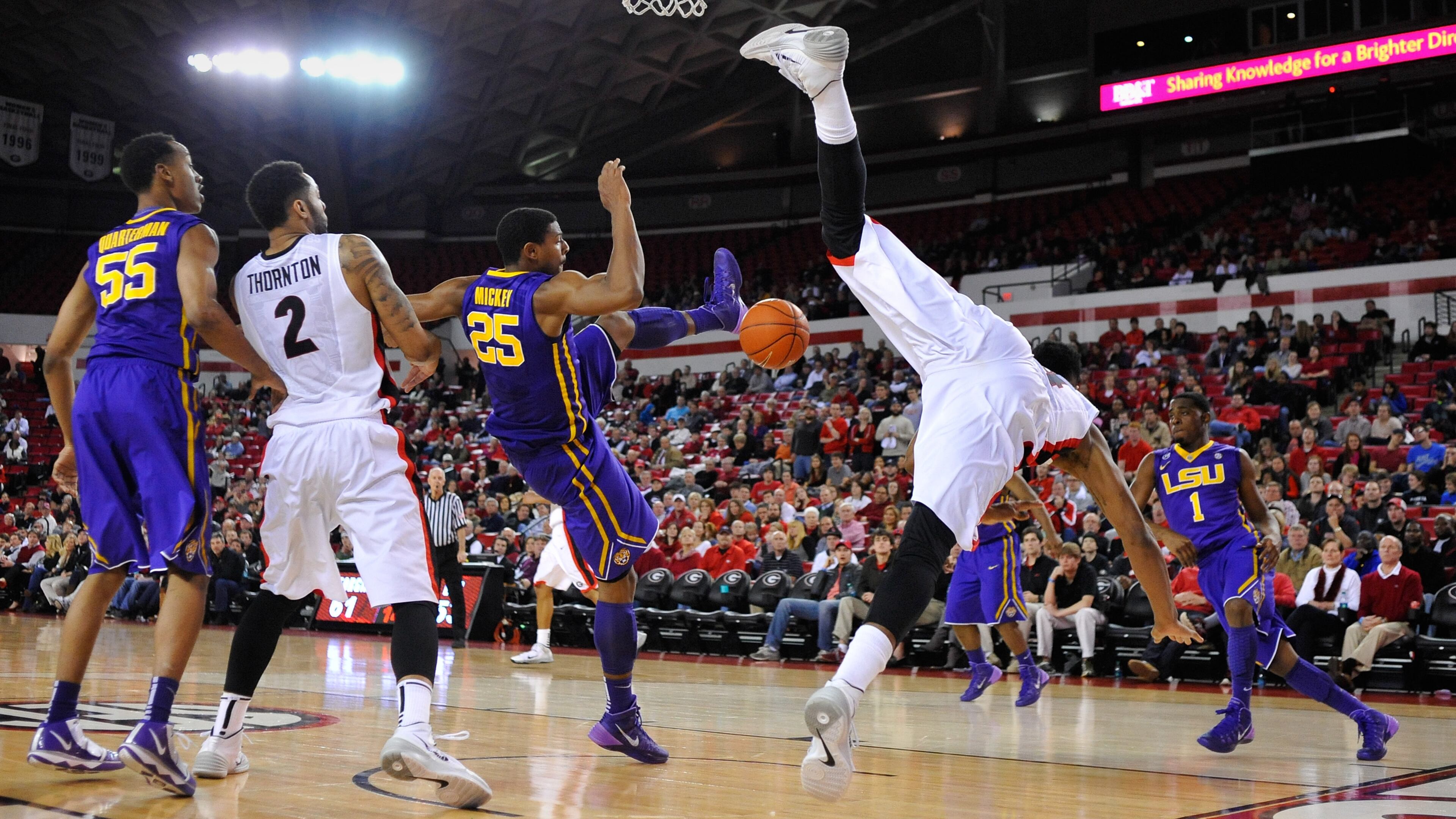 Georgia guard Charles Mann (4) goes off balance attempting a shot while defended by LSU forward Jordan Mickey (25) during the second half of an NCAA college basketball game on Thursday, Feb. 6, 2014 in Athens, Ga. Georgia won 91-78. Mann was injured on the play but returned later in the game. (AP Photo/Athens Banner-Herald, AJ Reynolds)