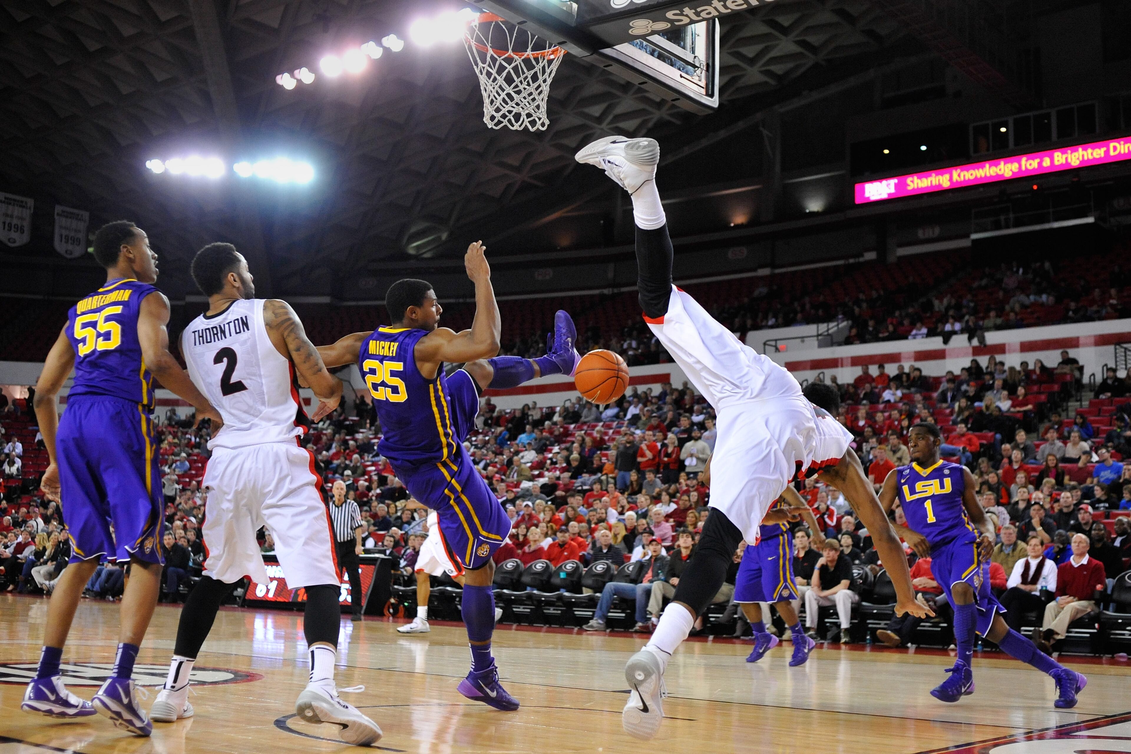 Georgia guard Charles Mann (4) goes off balance attempting a shot while defended by LSU forward Jordan Mickey (25) during the second half of an NCAA college basketball game on Thursday, Feb. 6, 2014 in Athens, Ga. Georgia won 91-78. Mann was injured on the play but returned later in the game. (AP Photo/Athens Banner-Herald, AJ Reynolds)