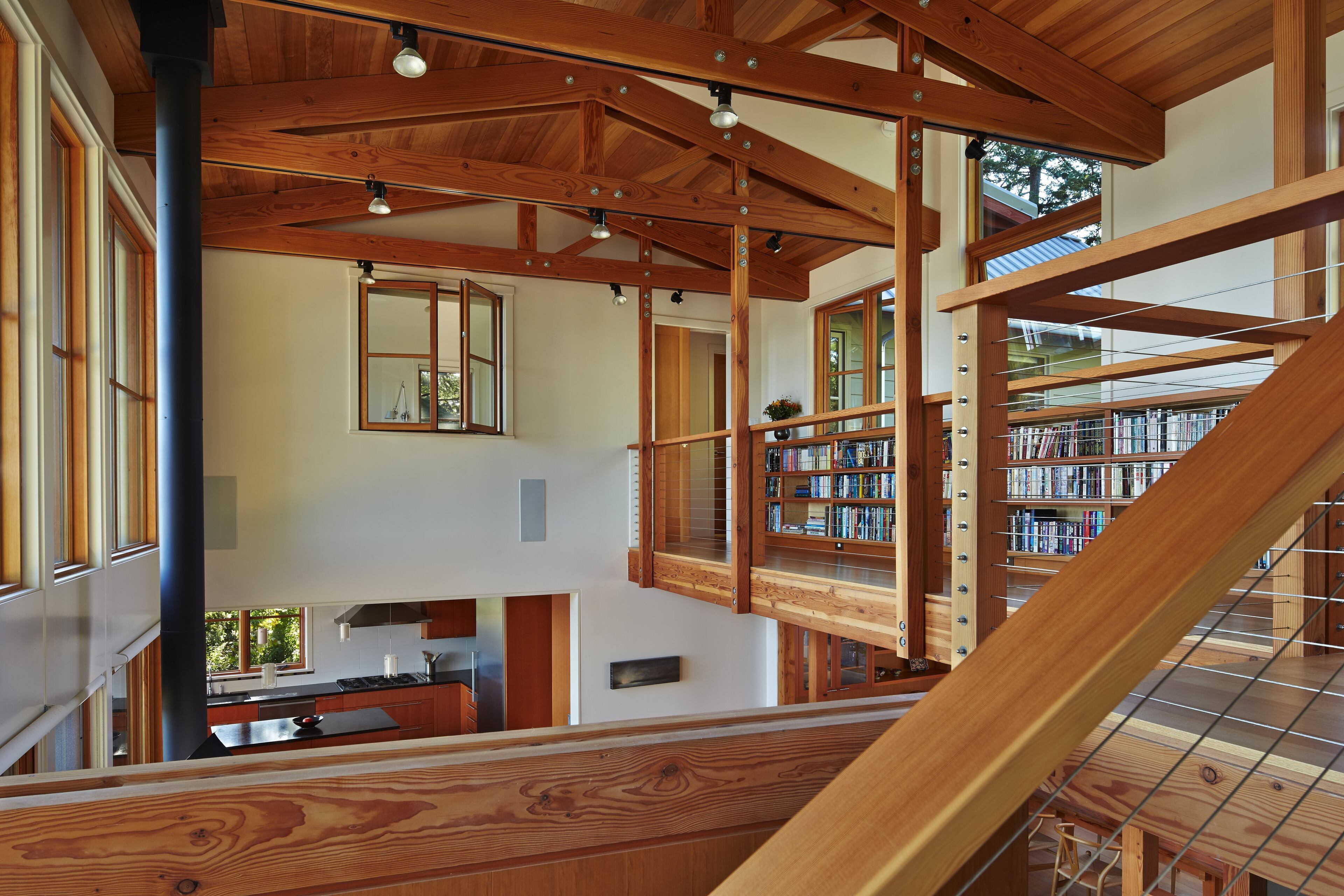 The home consists of two wings connected by this sky bridge, which also serves as a library. The use of fir throughout the home gives it a warm cabin feel. An interior window in each wing helps to connect spaces to the home's central living core. (Benjamin Benschneider/Seattle Times/MCT)