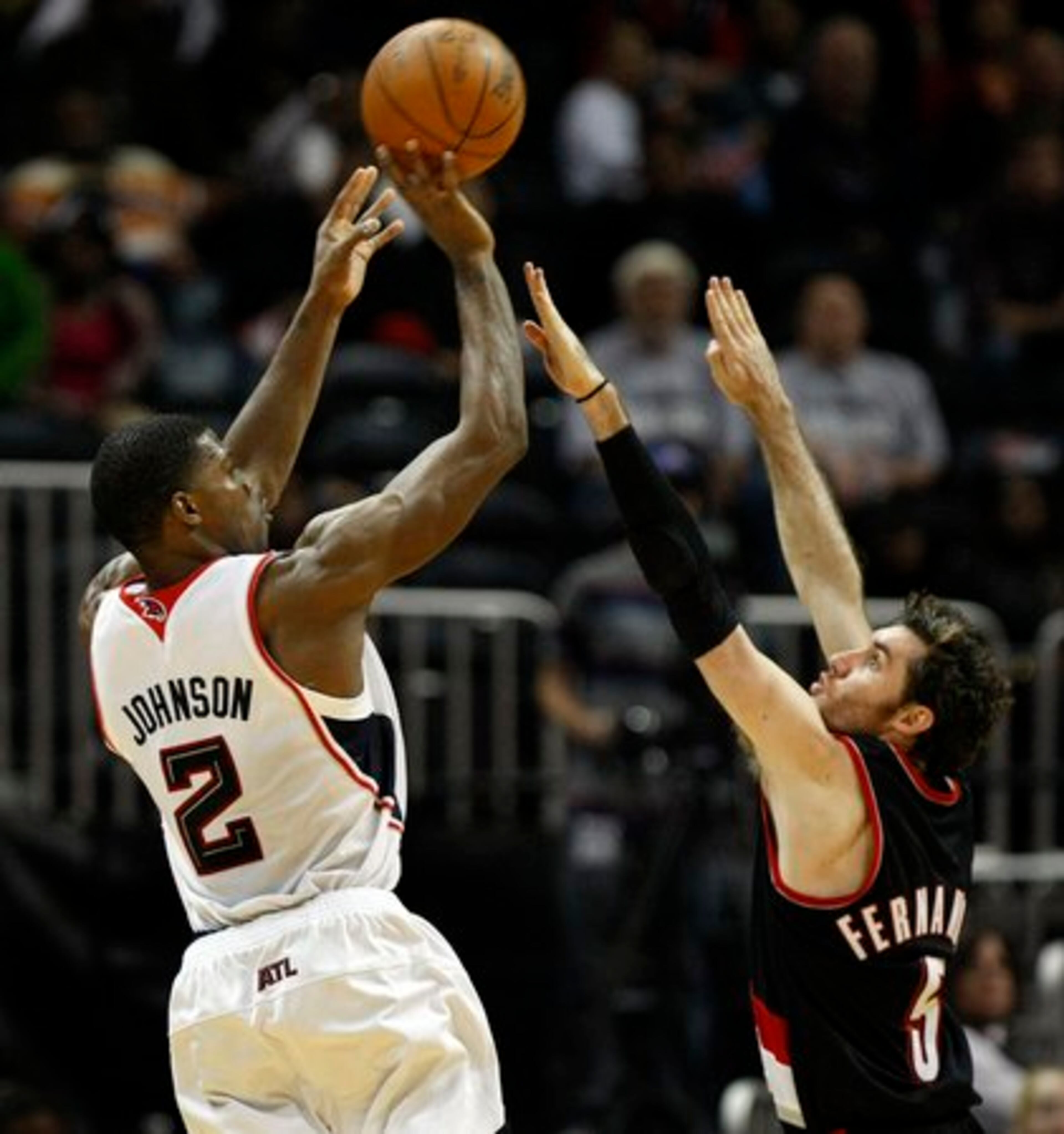 Hawks guard Joe Johnson shoots over Trail Blazers guard Rudy Fernandez for two of his 35 points.