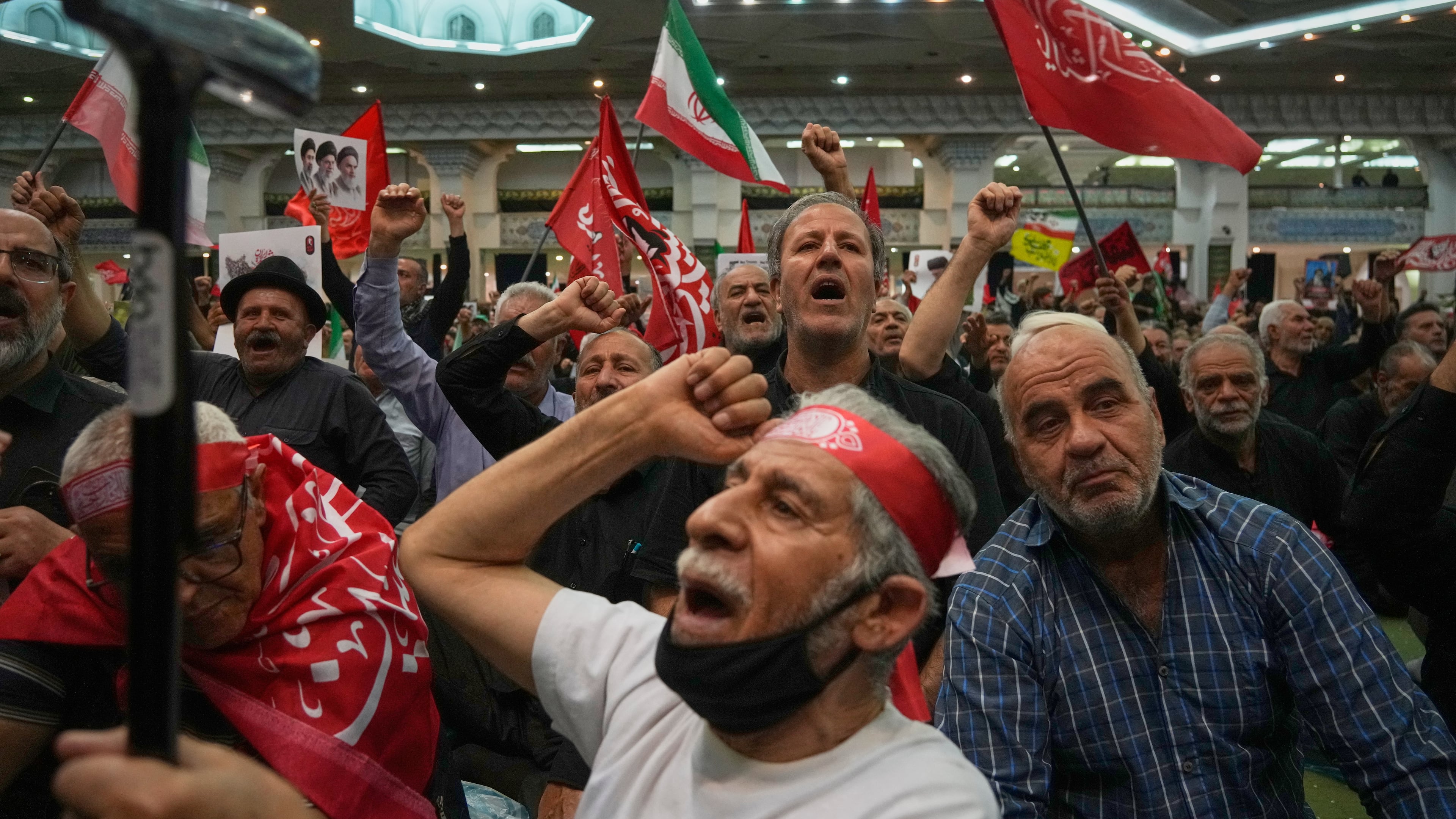 Mourners chant as they raise their fists during a gathering commemorating the late Supreme Leader Ali Khamenei at the Imam Khomeini Mosalla Grand Mosque in Tehran, Iran, Tuesday, July 14, 2026. (AP Photo/Vahid Salemi)