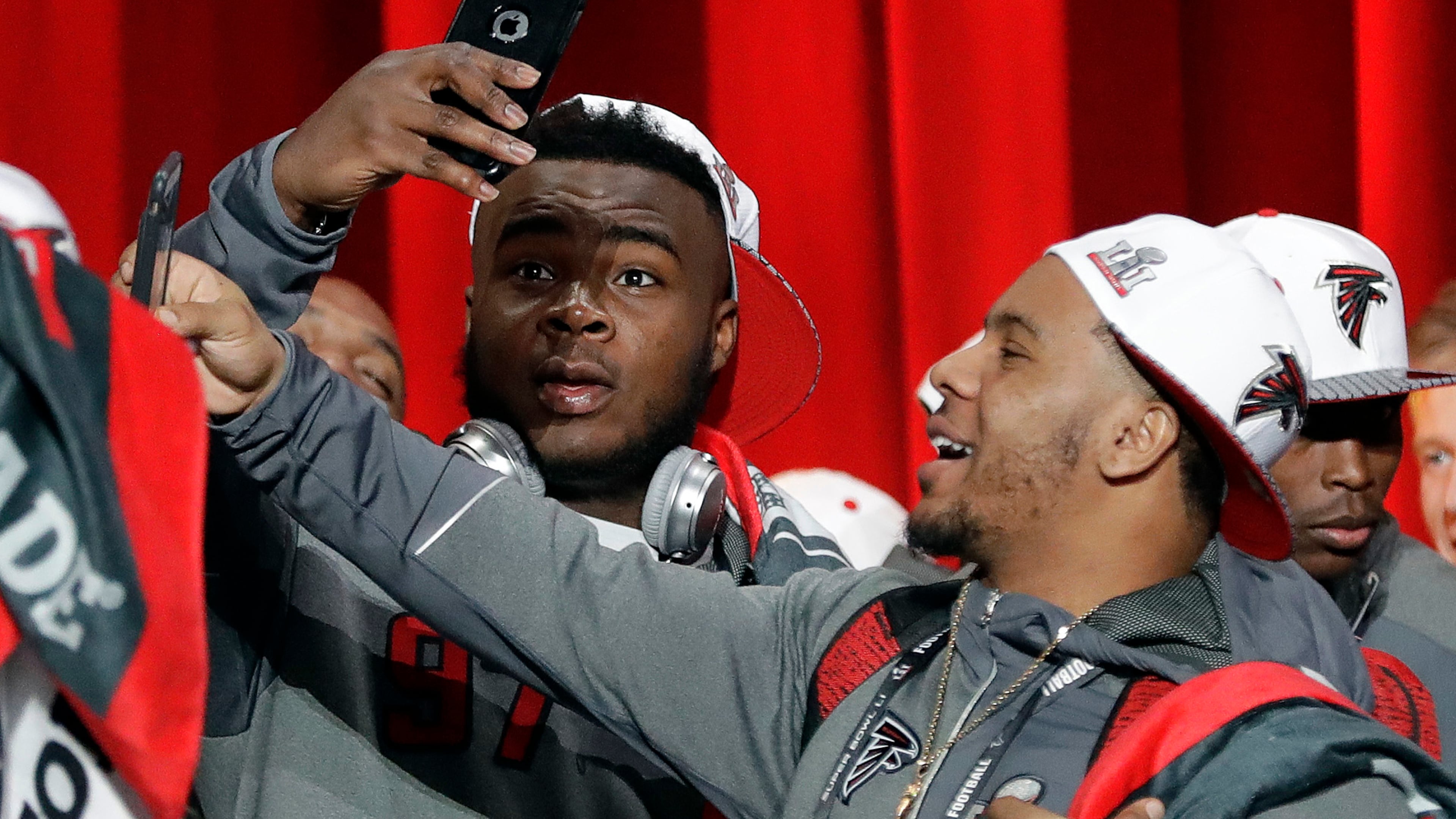 Atlanta Falcons' Grady Jarrett and Terron Ward take pictures during opening night for the NFL Super Bowl 51 football game at Minute Maid Park Monday, Jan. 30, 2017, in Houston. (AP Photo/David J. Phillip)