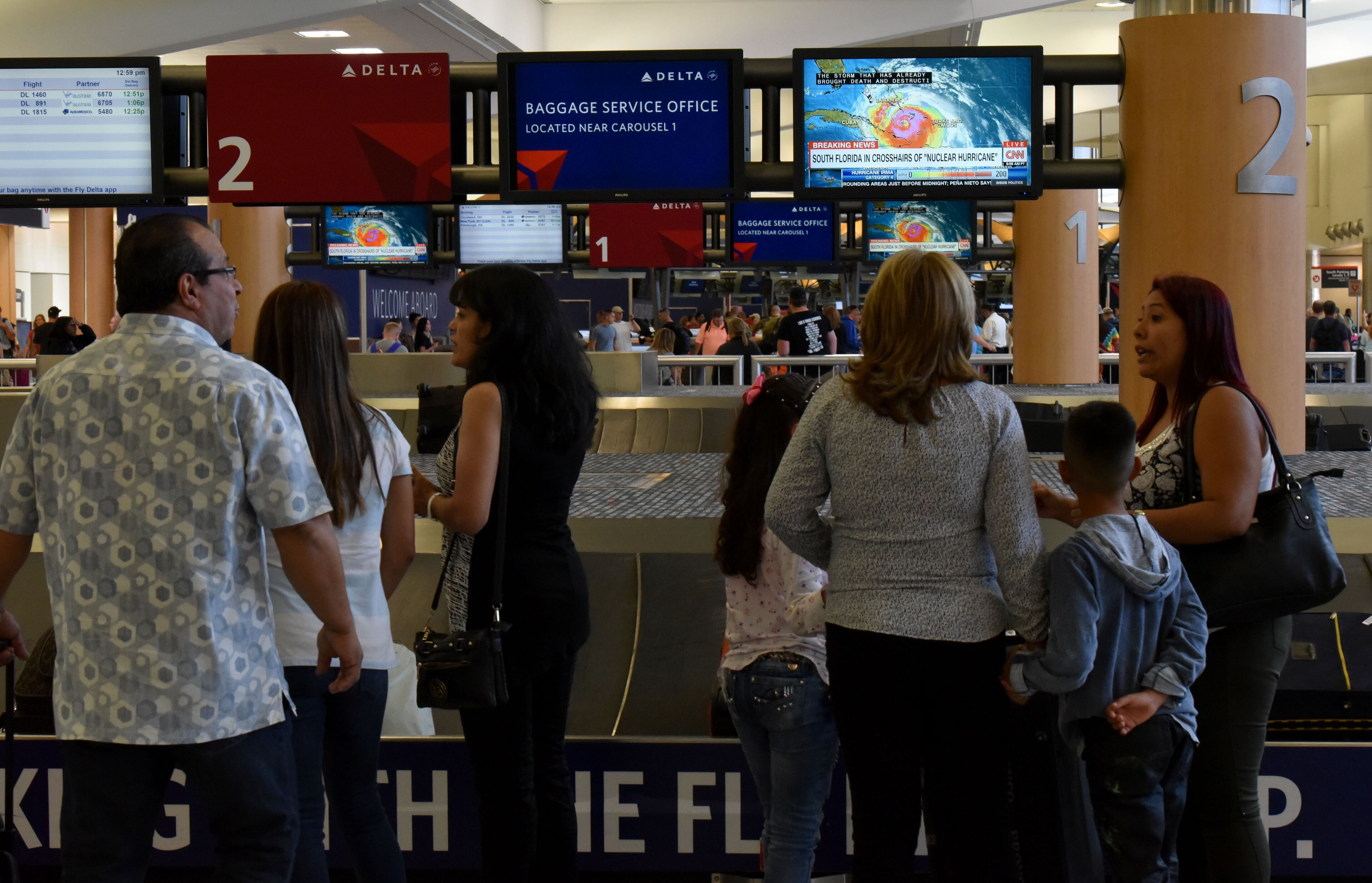 September 8, 2017 Atlanta - Airport customers watch latest weather report in baggage claim area at Hartsfield-Jackson Atlanta International Airport on Friday, September 8, 2017. Delta Air Lines is canceling about 260 flights in south Florida from Friday evening through Sunday. Overall, Delta has canceled about 320 flights, including cancellations in the Caribbean and the Bahamas that started Wednesday. HYOSUB SHIN / HSHIN@AJC.COM