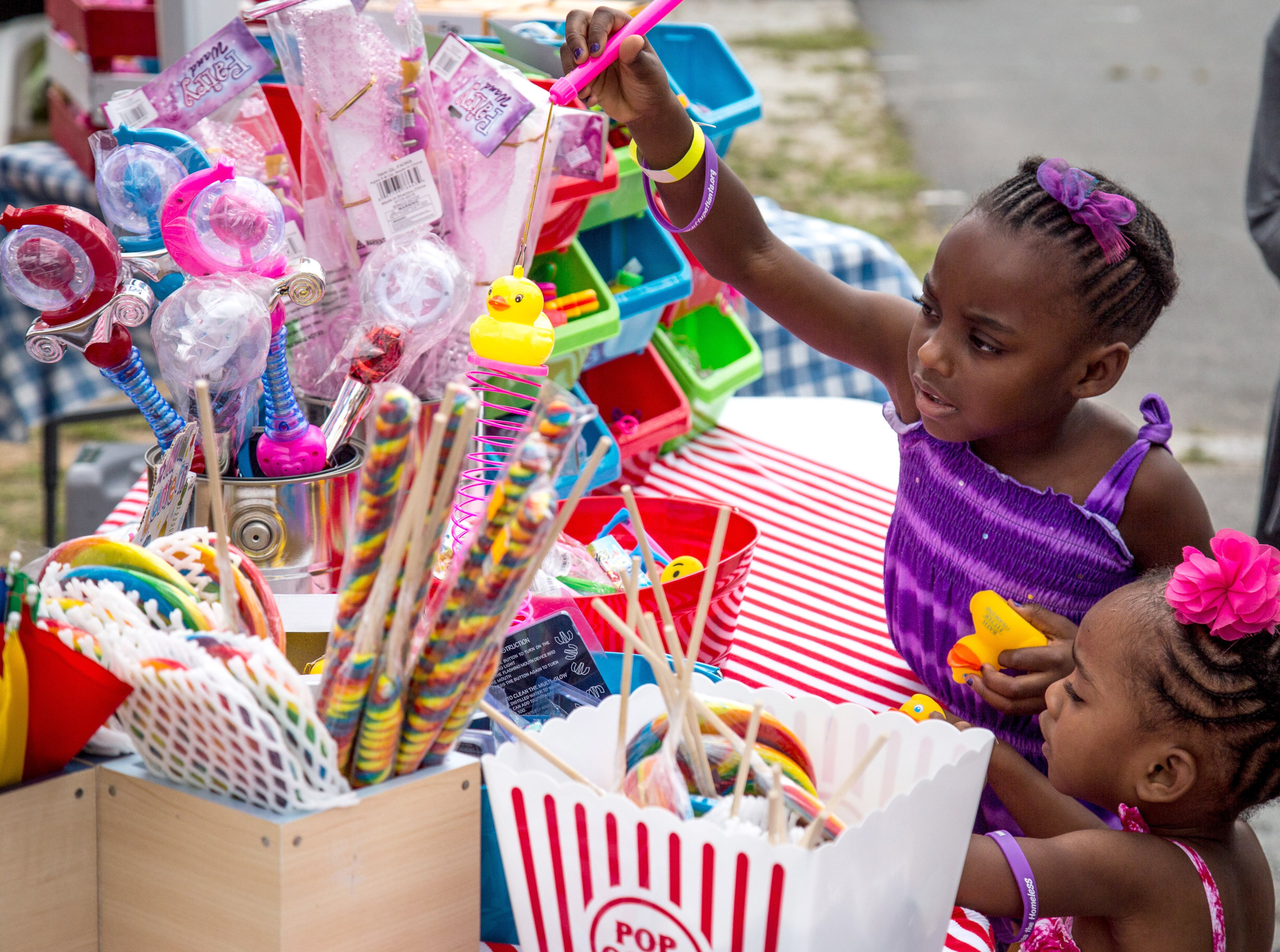 Yvette and Nicole Landford look over some of the toys for sale while at the Lift Up Summer Fun Festival on Saturday, June 18, 2016, in Lawrenceville, Ga. The proceeds from the festival will help homeless and low-income families. STEVE SCHAEFER / SPECIAL TO THE AJC