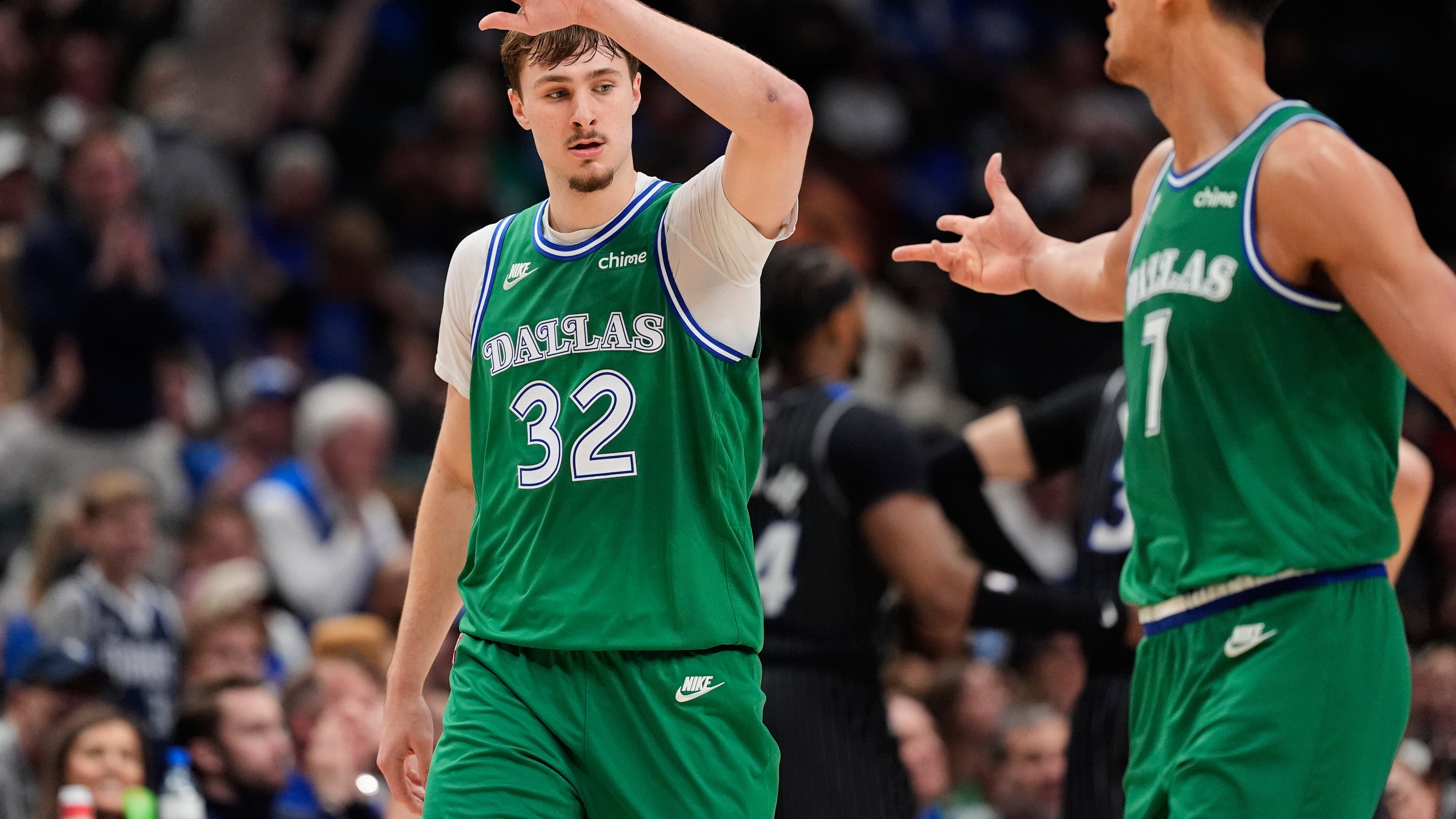 Dallas Mavericks forward Cooper Flagg (32) and Dwight Powell, right, celebrate a basket by Flagg in the second half of an NBA basketball game against the Orlando Magic Friday, April 3, 2026, in Dallas. (AP Photo/Tony Gutierrez)