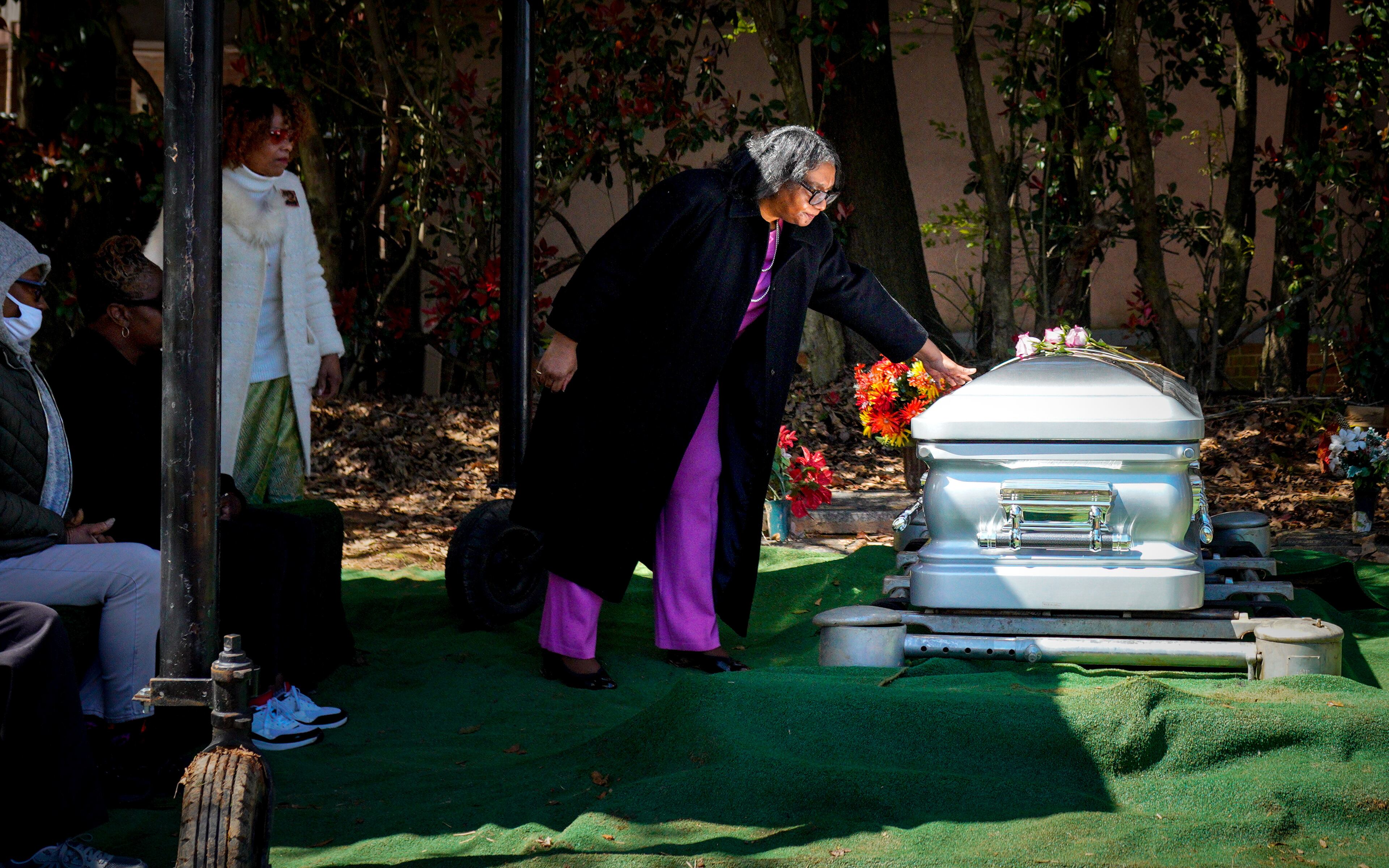 Trina Baynes says goodbye to her mother Helen Baynes as she is finally laid to rest. A broken backhoe had delayed the burial 14 days after the funeral.