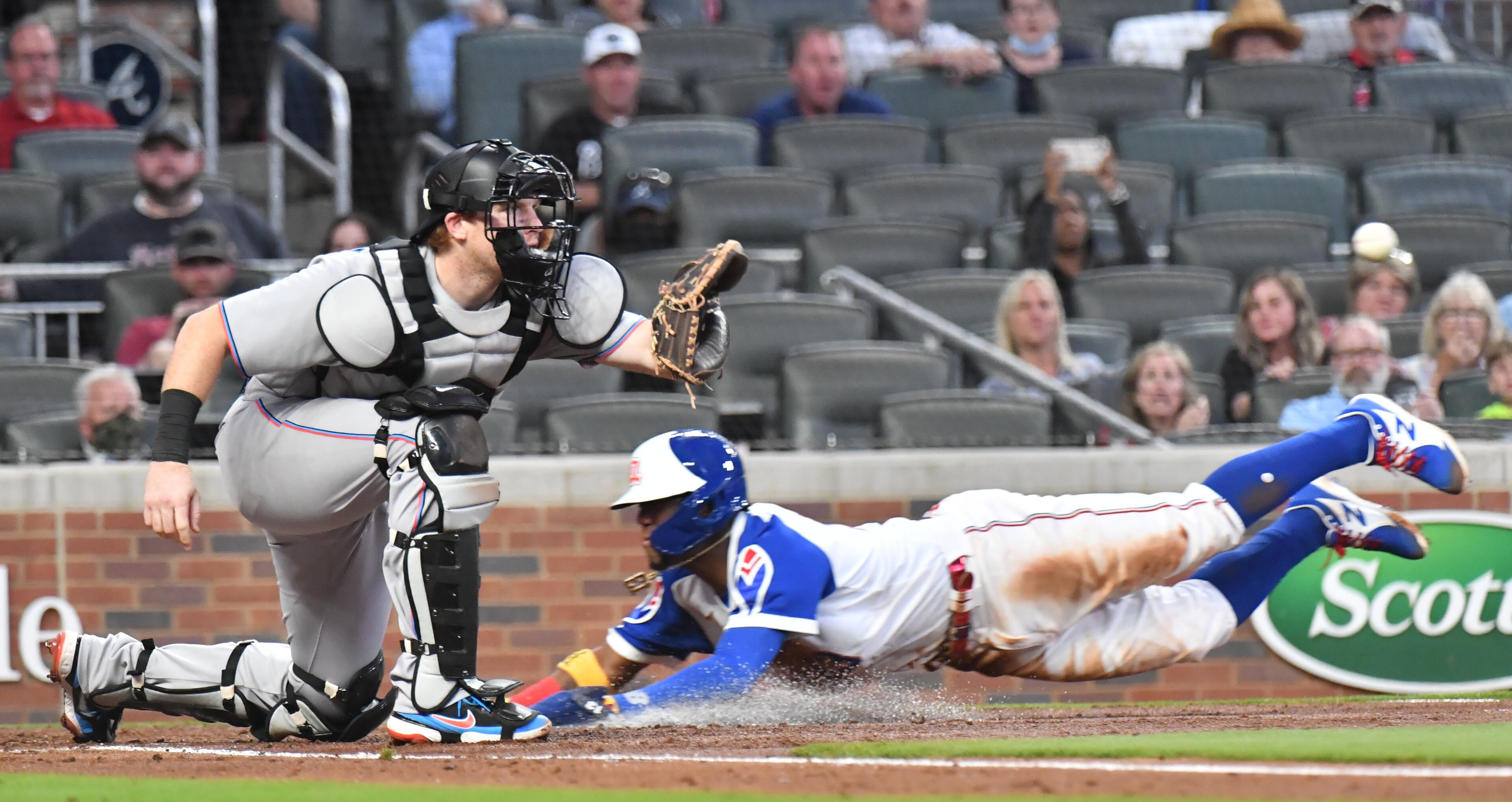 April 12, 2021 Atlanta - Atlanta Braves right fielder Ronald Acuna Jr. (13) scores past Miami Marlins catcher Chad Wallach (17) on a fly ball by Atlanta Braves second baseman Ozzie Albies (1) in the 3rd inning at Truist Park on Monday, April 12, 2021. (Hyosub Shin / Hyosub.Shin@ajc.com)