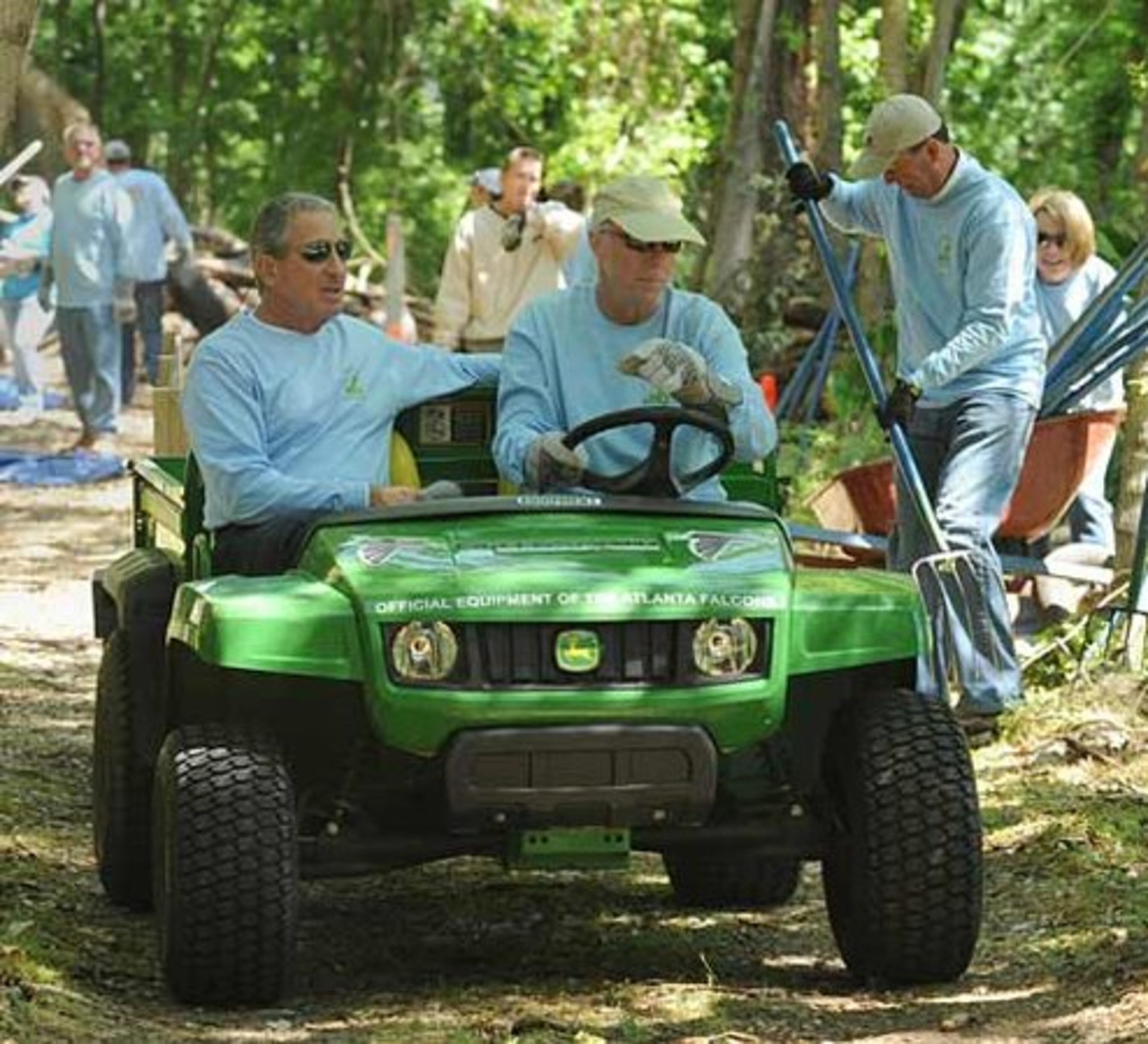 Atlanta Falcons owner Arthur Blank rides as Falcons President Rich McKay drives a cart filled with chipped wood on a trail behind the Washington Park Tennis Center on Thursday, May 5,2011. This was one of the Arthur M. Blank Family of Businesses team-oriented projects to improve the local community.