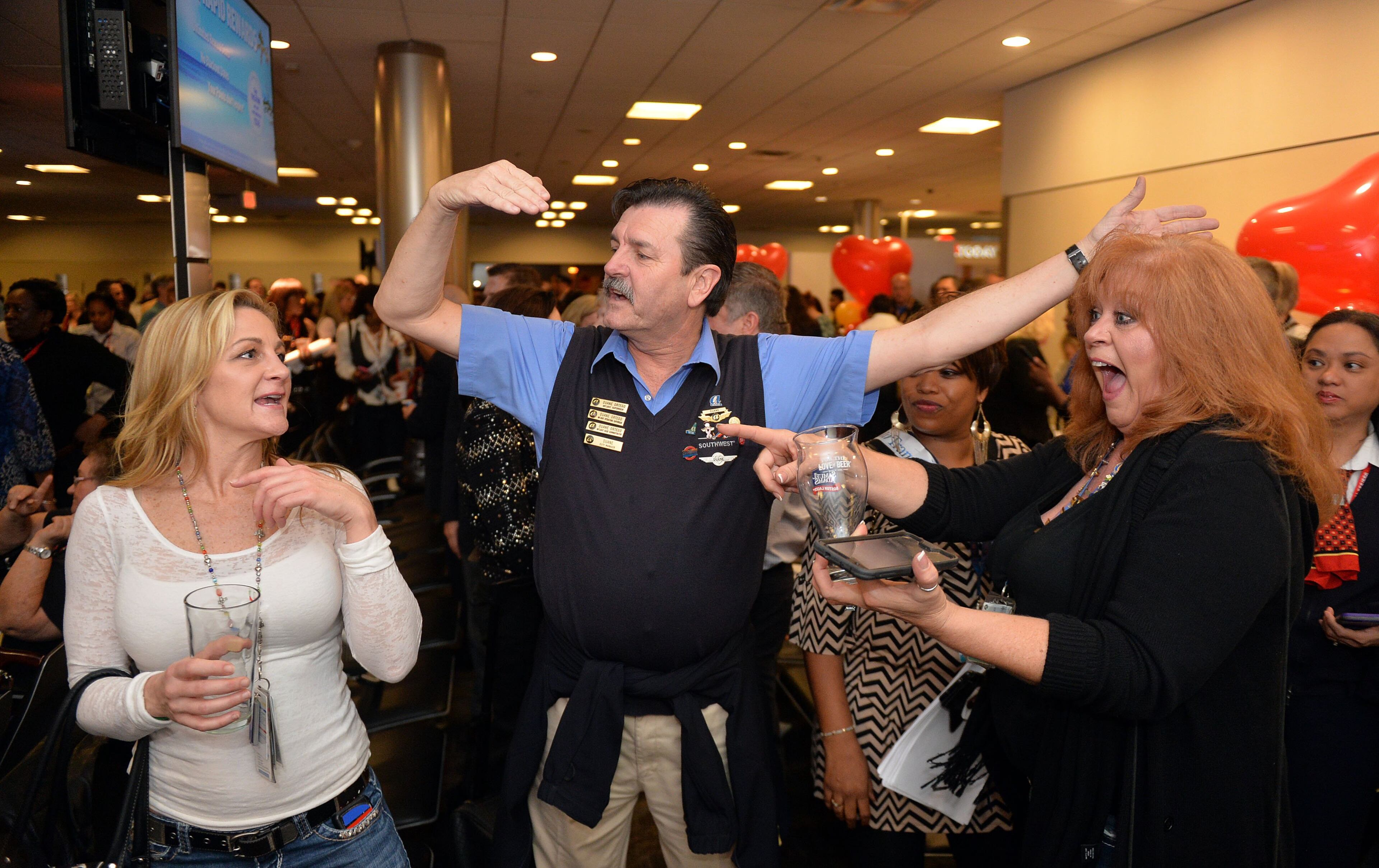 Flight attendants Tara Cortes (from left) Duane Ortego and Suzanne Wayda celebrate during the event. Hundreds of Southwest Airlines and former AirTran Airways employees gathered at Concourse C, gates 1, 2 and 3 to celebrate the departure of AirTran’s final flight to Tampa, at Hartsfield-Jackson International Airport, Sunday, December 28, 2014. Southwest CEO Gary Kelly and executives Bob Jordan and Jack Smith gave remarks during the program. The full flight was waved off by employees that gathered on the tarmac as crash trucks from Atlanta Fire Rescue gave a final water cannon salute as the plane departed. KENT D. JOHNSON/KDJOHNSON@AJC.COM