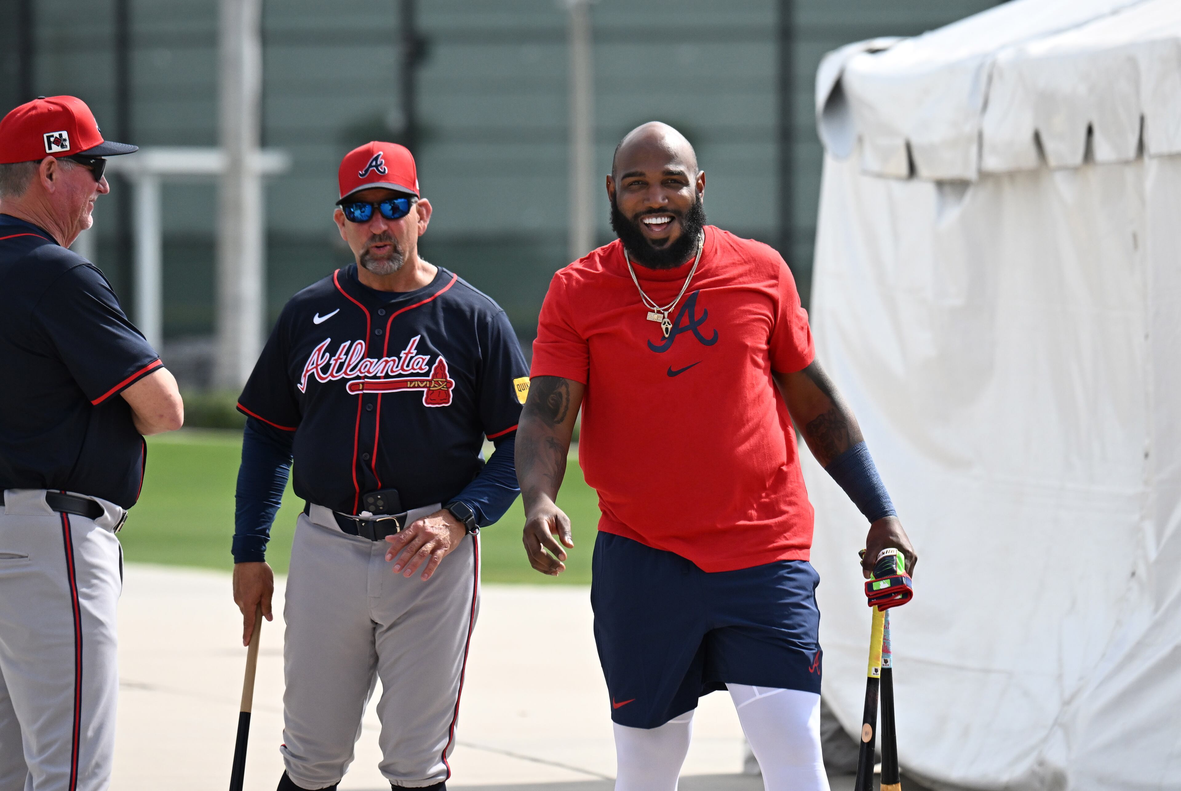 Atlanta Braves designated hitter Marcell Ozuna (right) smiles as he is greeted by coaching staff during spring training workouts at CoolToday Park, Sunday, February 16, 2025, North Port, Florida. (Hyosub Shin / AJC)
