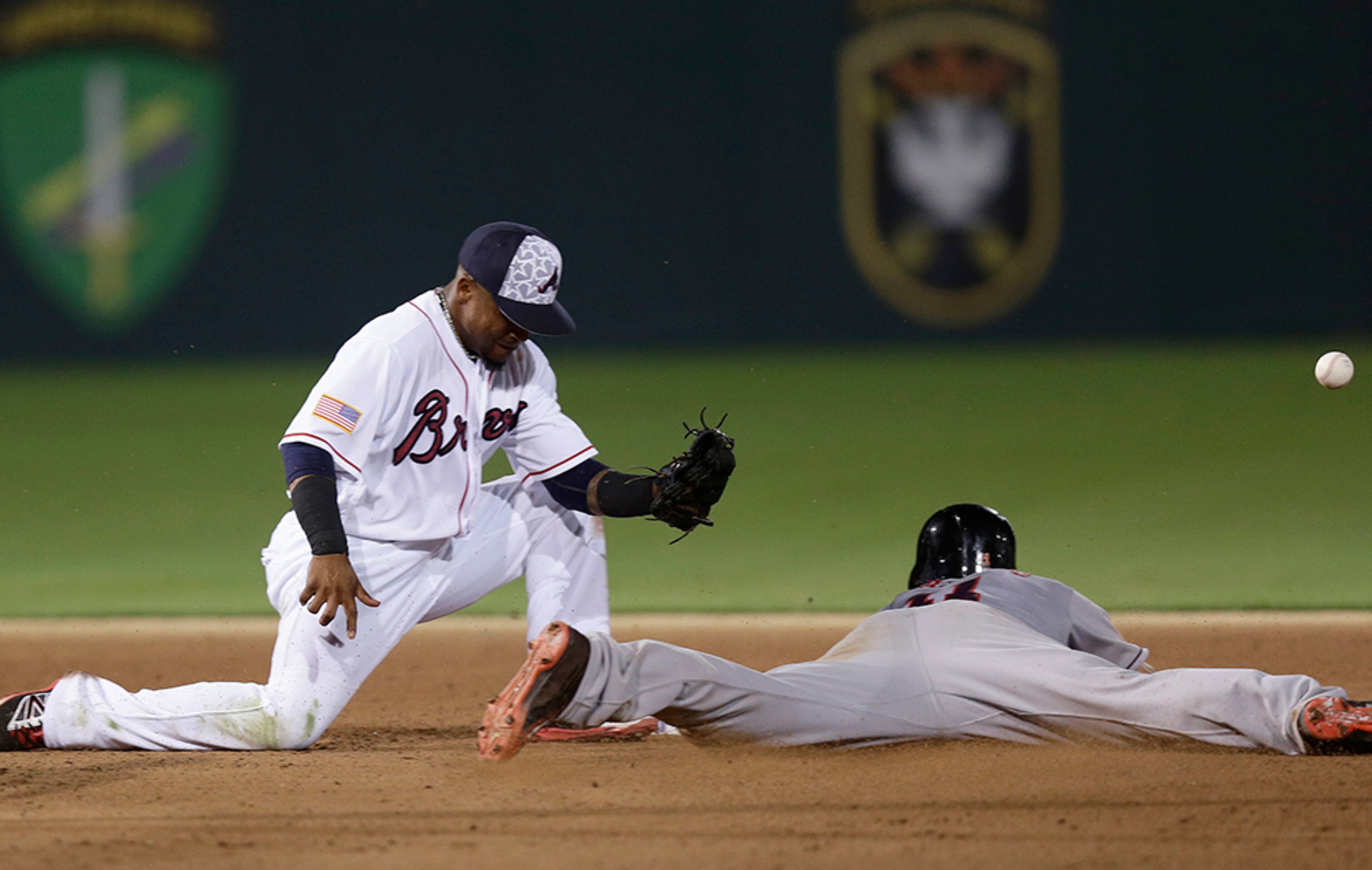Miami Marlins' J.T. Realmuto slides safely into second base as Atlanta Braves shortstop Erick Aybar misses the throw during eighth inning of a baseball game in Fort Bragg, N.C., Sunday, July 3, 2016. Miami won 5-2.