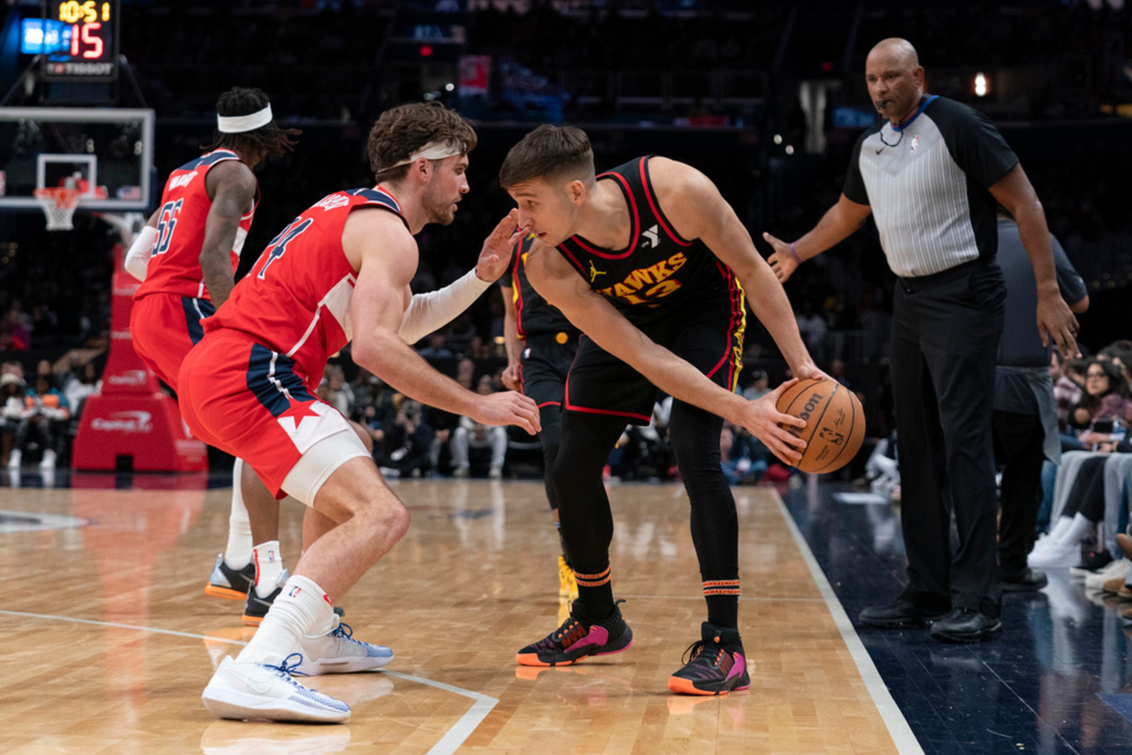 Atlanta Hawks' Bogdan Bogdanovic (13) drives the ball as Washington Wizards' Corey Kispert, front left, tries to block during the second half of an NBA basketball game Sunday, Dec. 31, 2023, in Washington. (AP Photo/Jose Luis Magana)