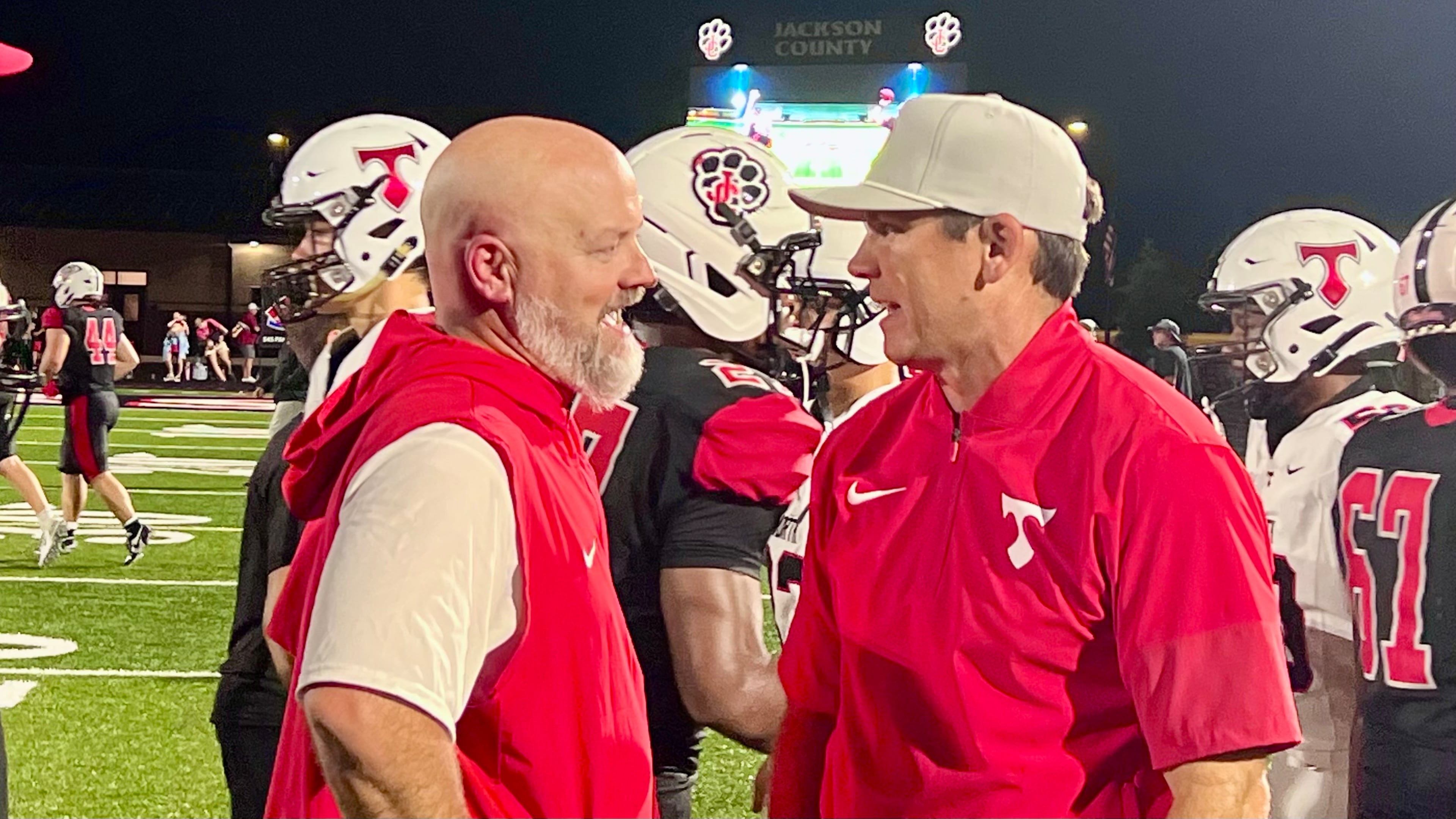 Jackson County coach Korey Mobbs, left, and North Oconee coach Tyler Aurandt, right, talk after a game on Sept. 12, 2026.