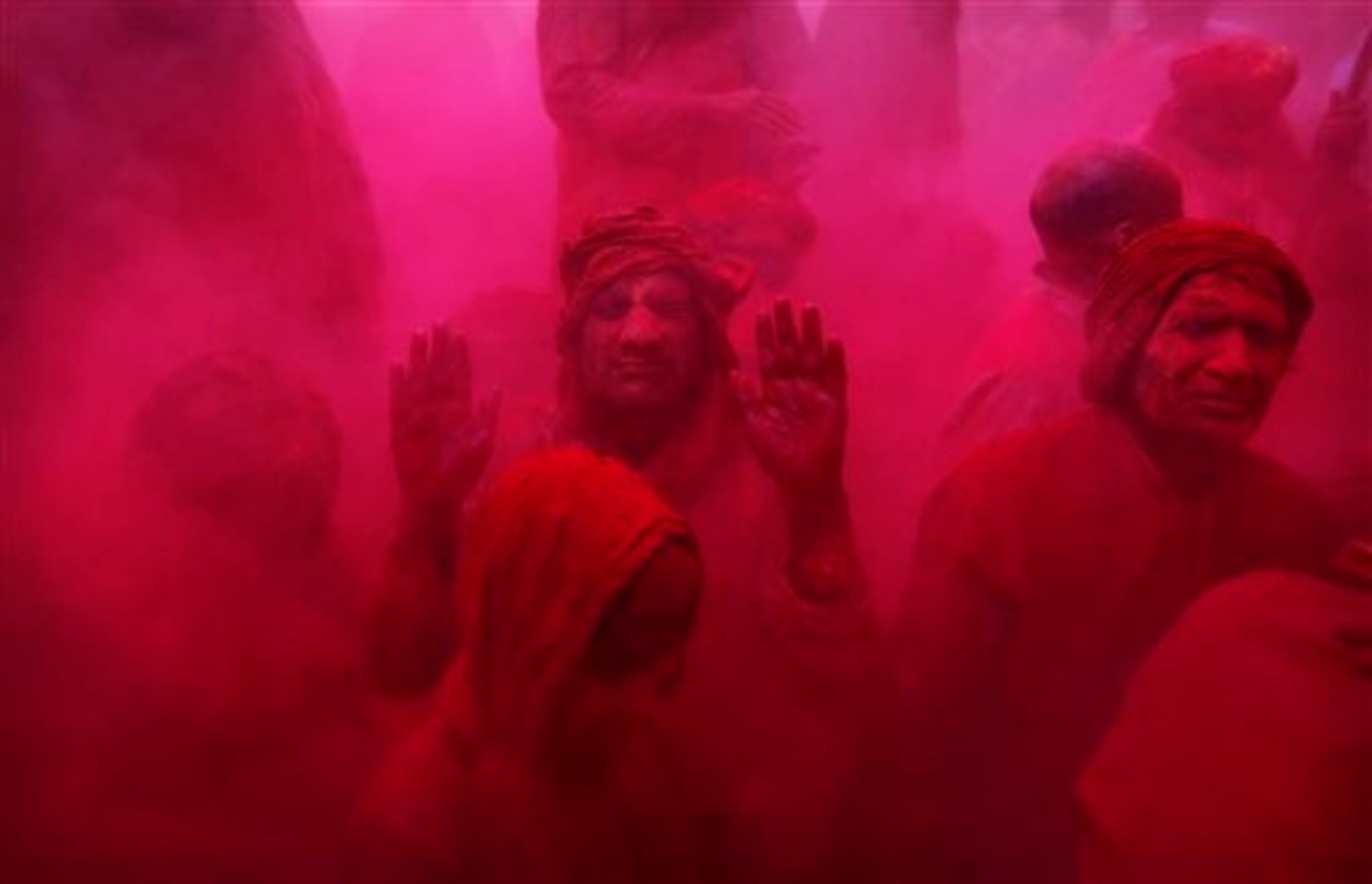Hindu men and a boy from the village of Nangaon are covered in colored powder as they sit on the floor during prayers at the Ladali or Radha temple before the procession for the Lathmar Holy festival, the legendary hometown of Radha, consort of Hindu God Krishna, in Barsana, 115 kilometers (71 miles) from New Delhi, India, Thursday, March 21, 2013. During Lathmar Holi the women of Barsana beat the men from Nandgaon, the hometown of Krishna, with wooden sticks in response to their teasing as they depart the town. (AP Photo/Kevin Frayer)