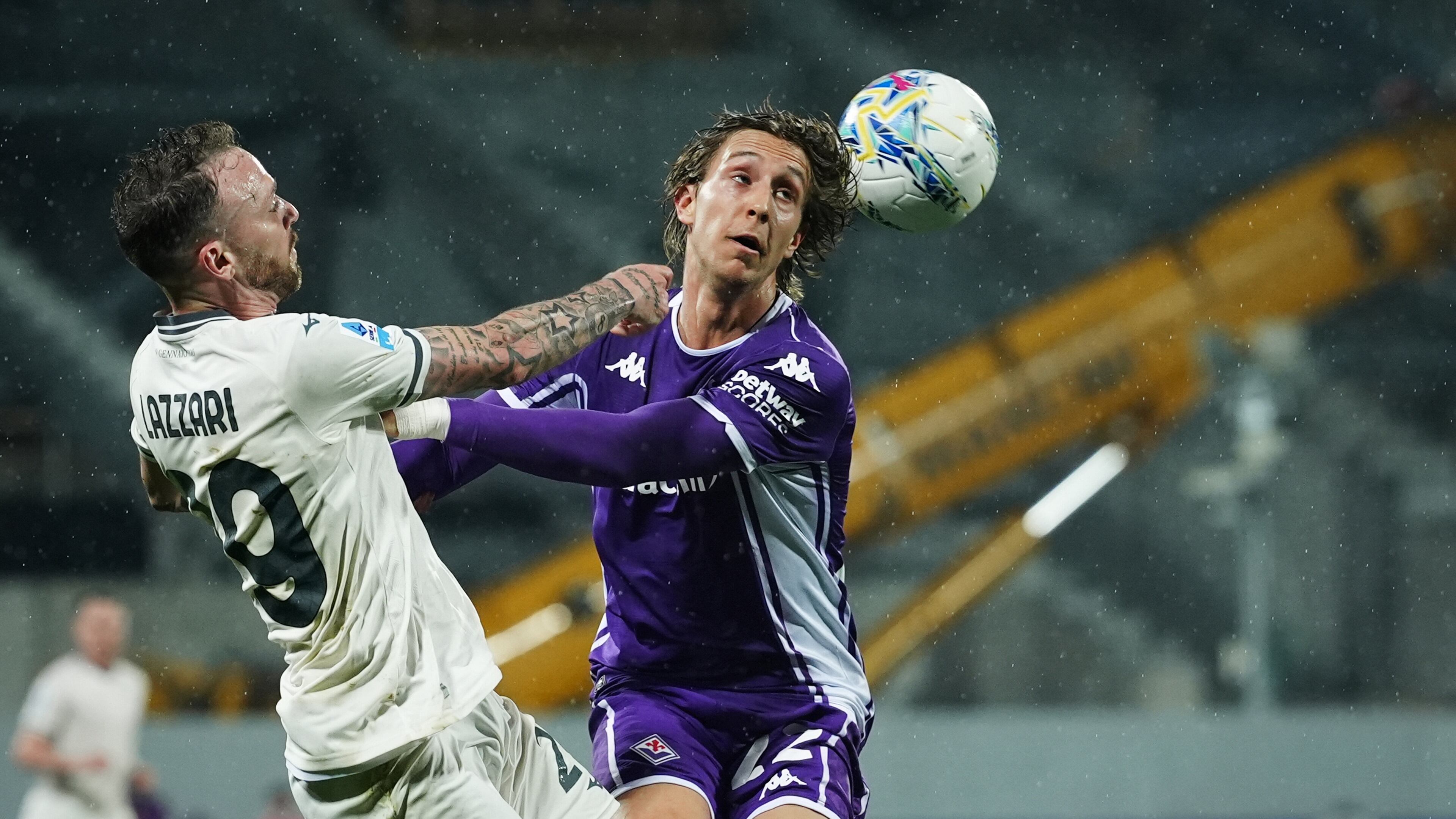 Lazio's Manuel Lazzari, left, fights for the ball with Fiorentina's Jacopo Fazzini during the Serie A soccer match between Fiorentina and Lazio in Florence, Italy, Monday, April 13, 2026. (Massimo Paolone/LaPresse via AP)