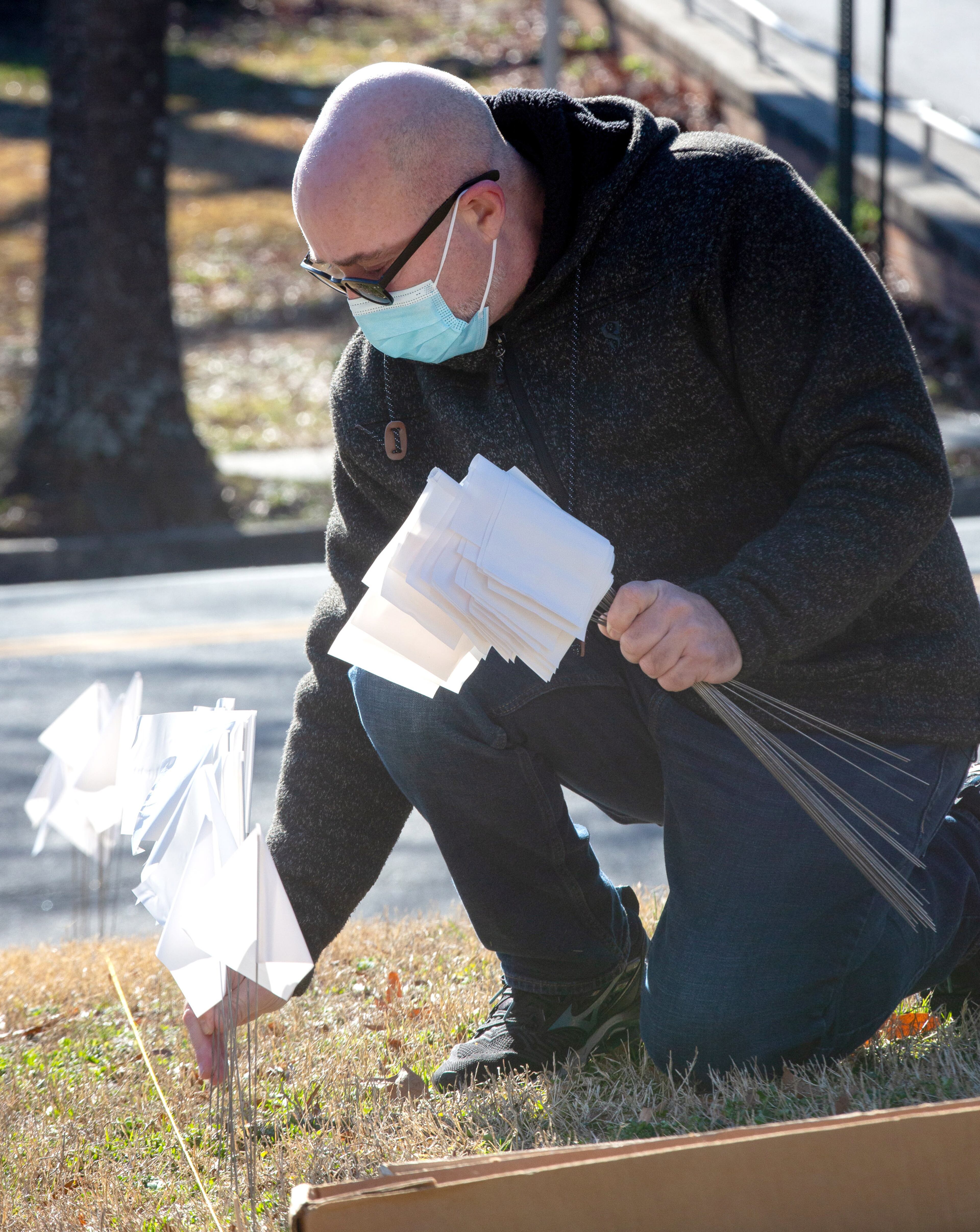 John Herberger plants some of the 15,000 flags on the lawn of First Christian Church of Decatur on Saturday, February 20, 2021. The flags represent the number of COVID-19 deaths in Georgia, and the effort aims to raise awareness about the toll of the coronavirus. (Photo: Steve Schaefer for The Atlanta Journal-Constitution)