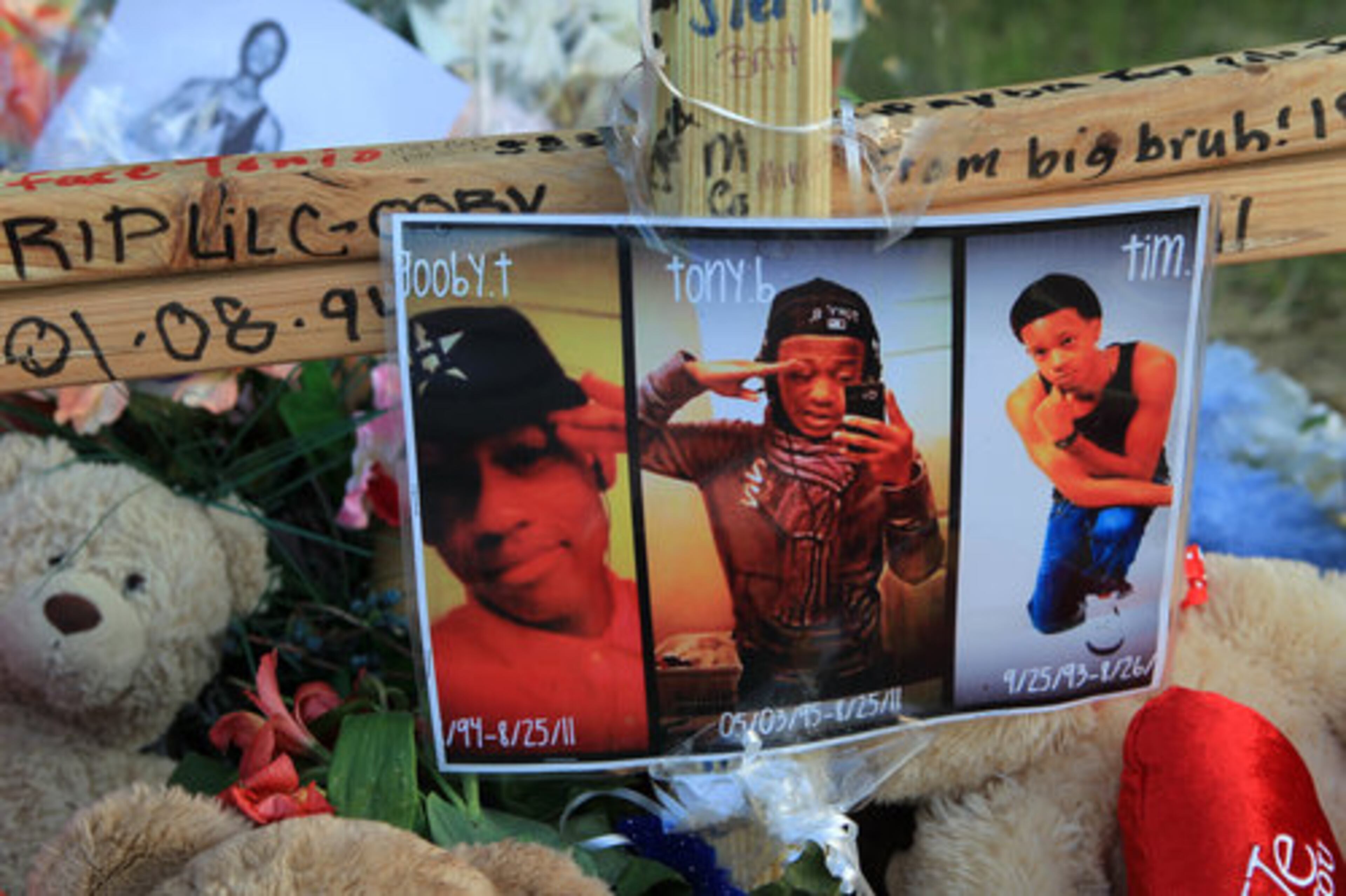 A photograph of Octavius Sorrells, Antonious Bishop, and Timothy Aaron sits in the middle of a roadside shrine at the site in Stockbridge where they were fatally hit by a car on Aug. 25.