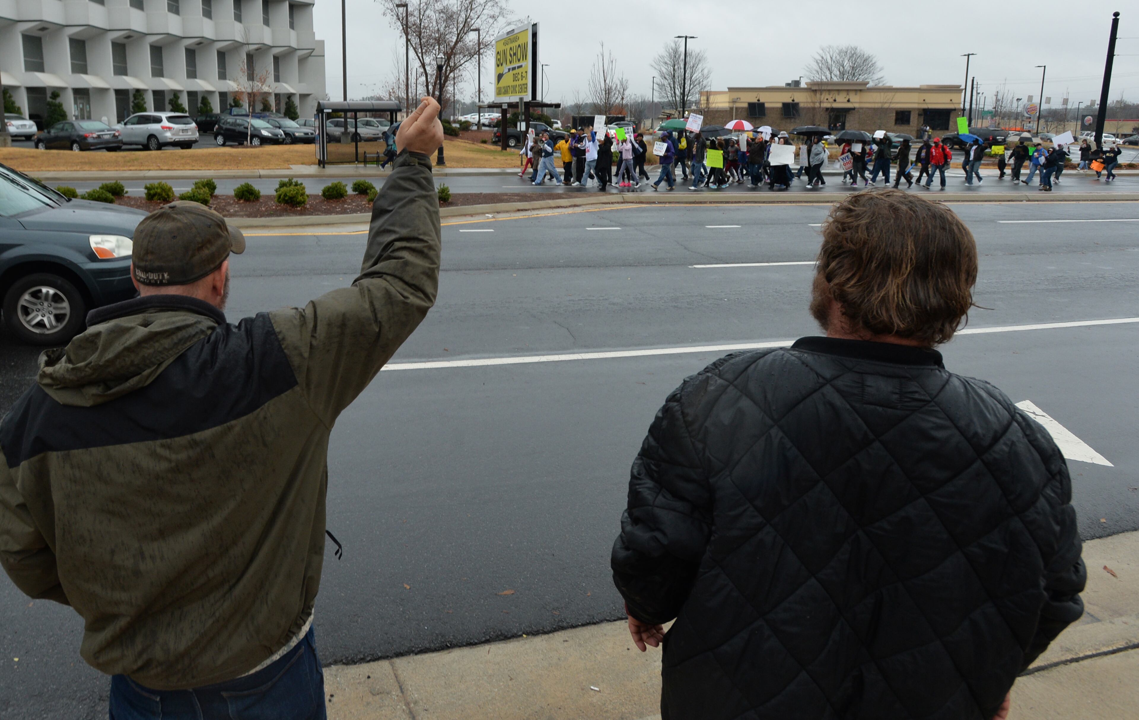 December 6, 2014 Marietta - Supporters cheer as protesters march toward the Marietta Square during their peaceful demonstration against decisions not to indict white police officers in the deaths of unarmed black men in Ferguson, Mo., and in New York City on Saturday, December 6, 2014. HYOSUB SHIN / HSHIN@AJC.COM
