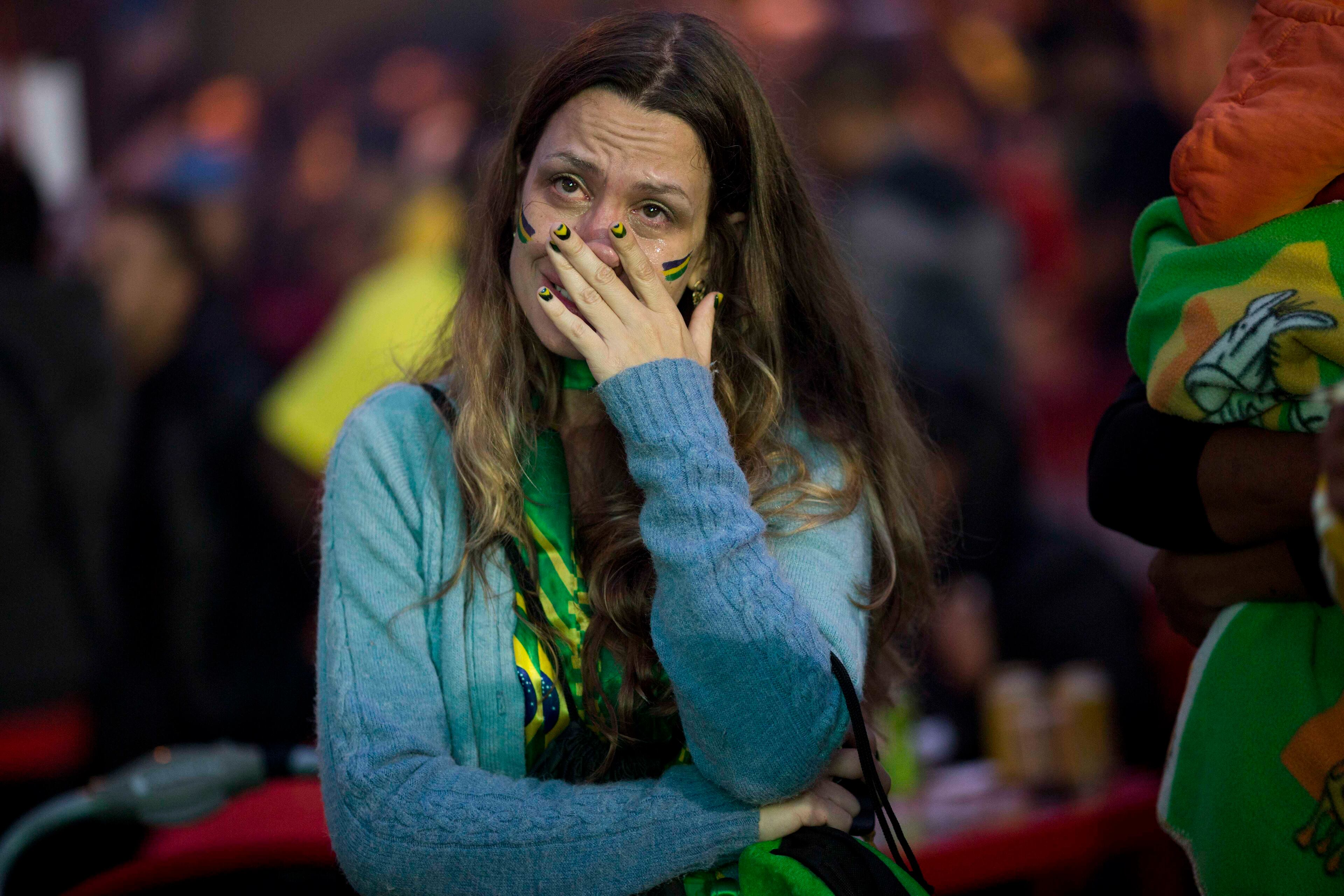 A Brazil soccer fan cries as she watches her team play Germany in a World Cup semifinal game via live telecast in Sao Paulo, Brazil, Tuesday, July 8, 2014. (AP Photo/Rodrigo Abd)