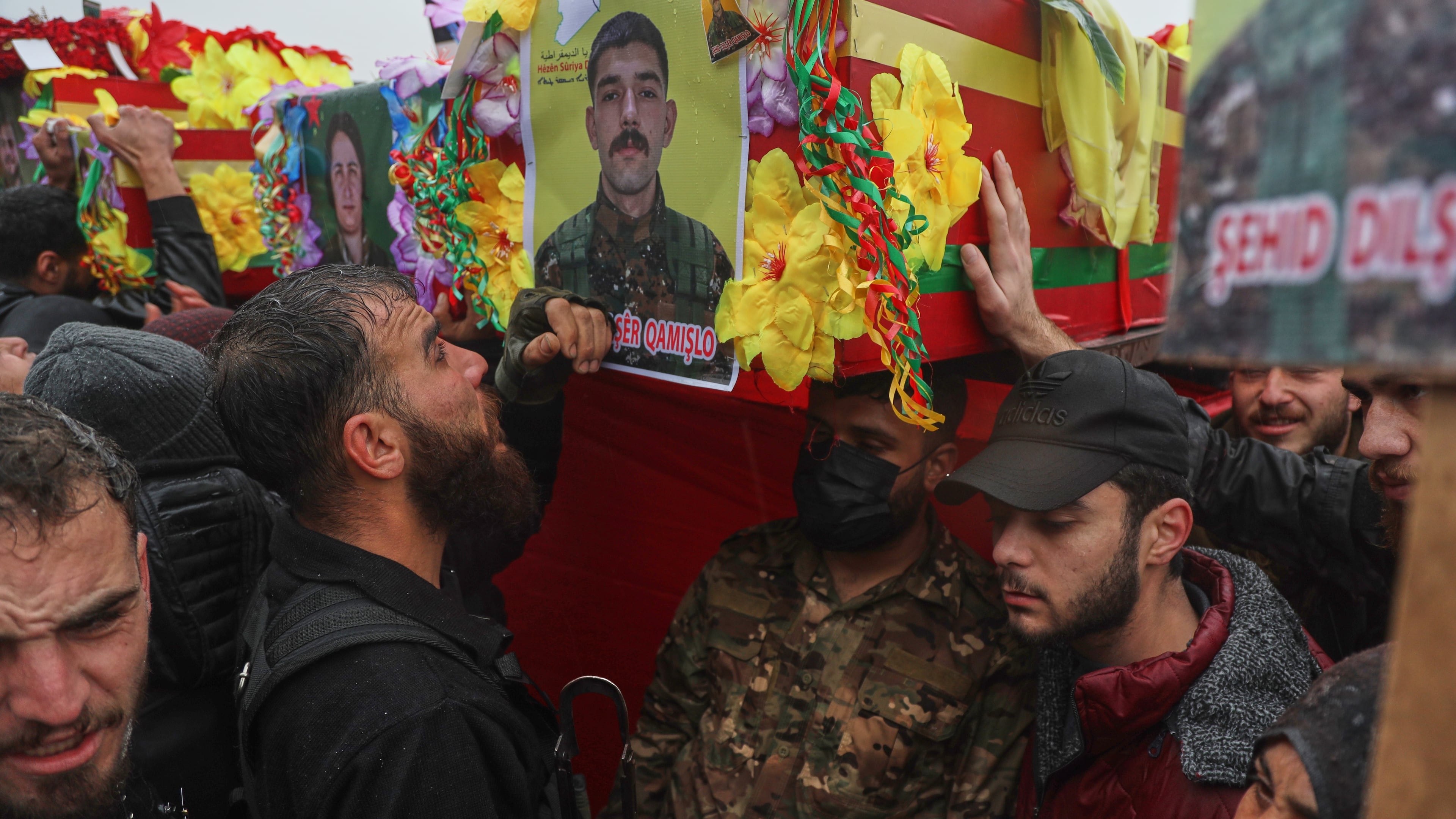Soldiers carry coffins during the funeral of Kurdish-led Syrian Democratic Forces (SDF) fighters killed earlier this month during clashes with Syrian government forces, in Qamishli, northeastern Syria, Wednesday, Jan. 28, 2026. (AP Photo/Baderkhan Ahmad)