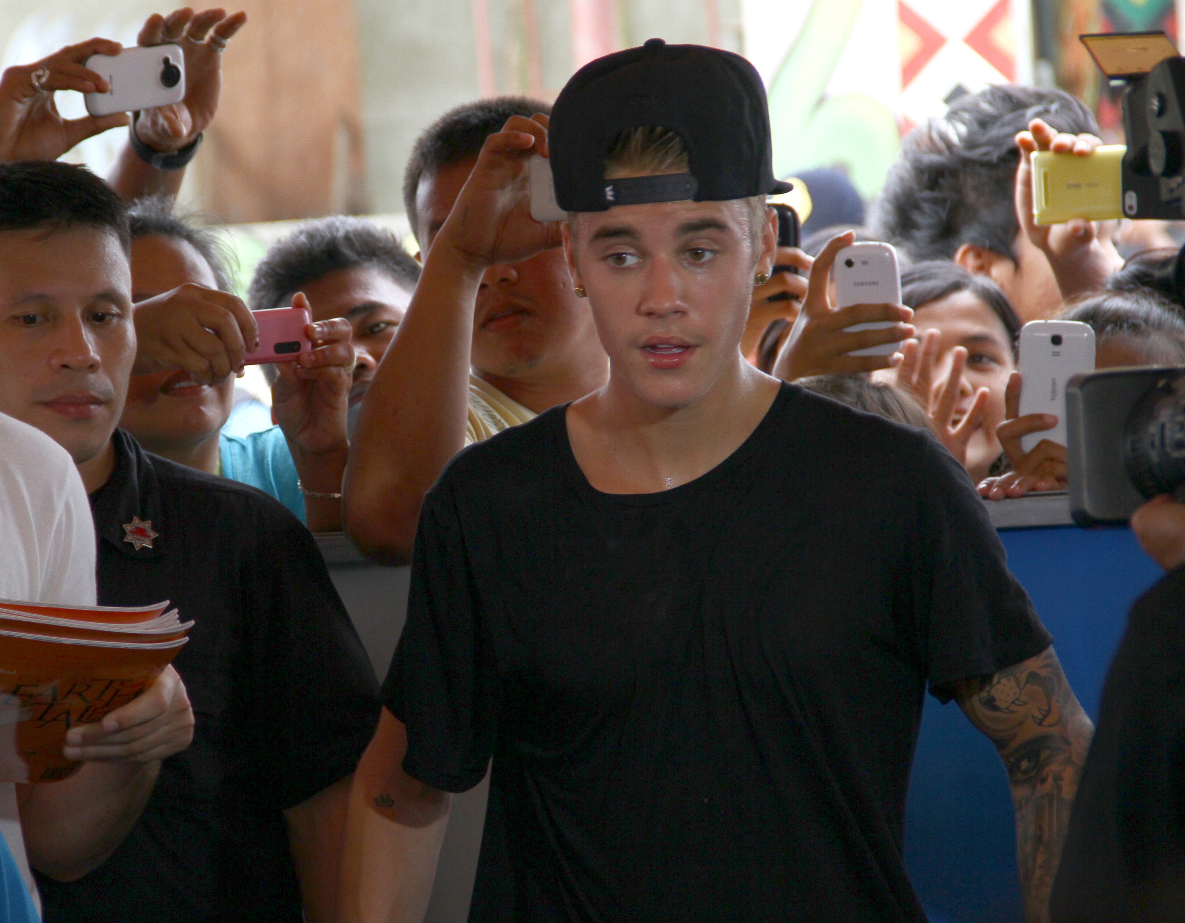 Justin Bieber prepares to greet his fans after playing basketball with children survivors of Typhoon Haiyan during his visit to Tacloban city, Leyte province in central Philippines, Tuesday, Dec. 10, 2013. The teen heartthrob Bieber arrived Tuesday in the Philippines, where he has launched a campaign to help victims of last month's killer typhoon. (AP Photo)
