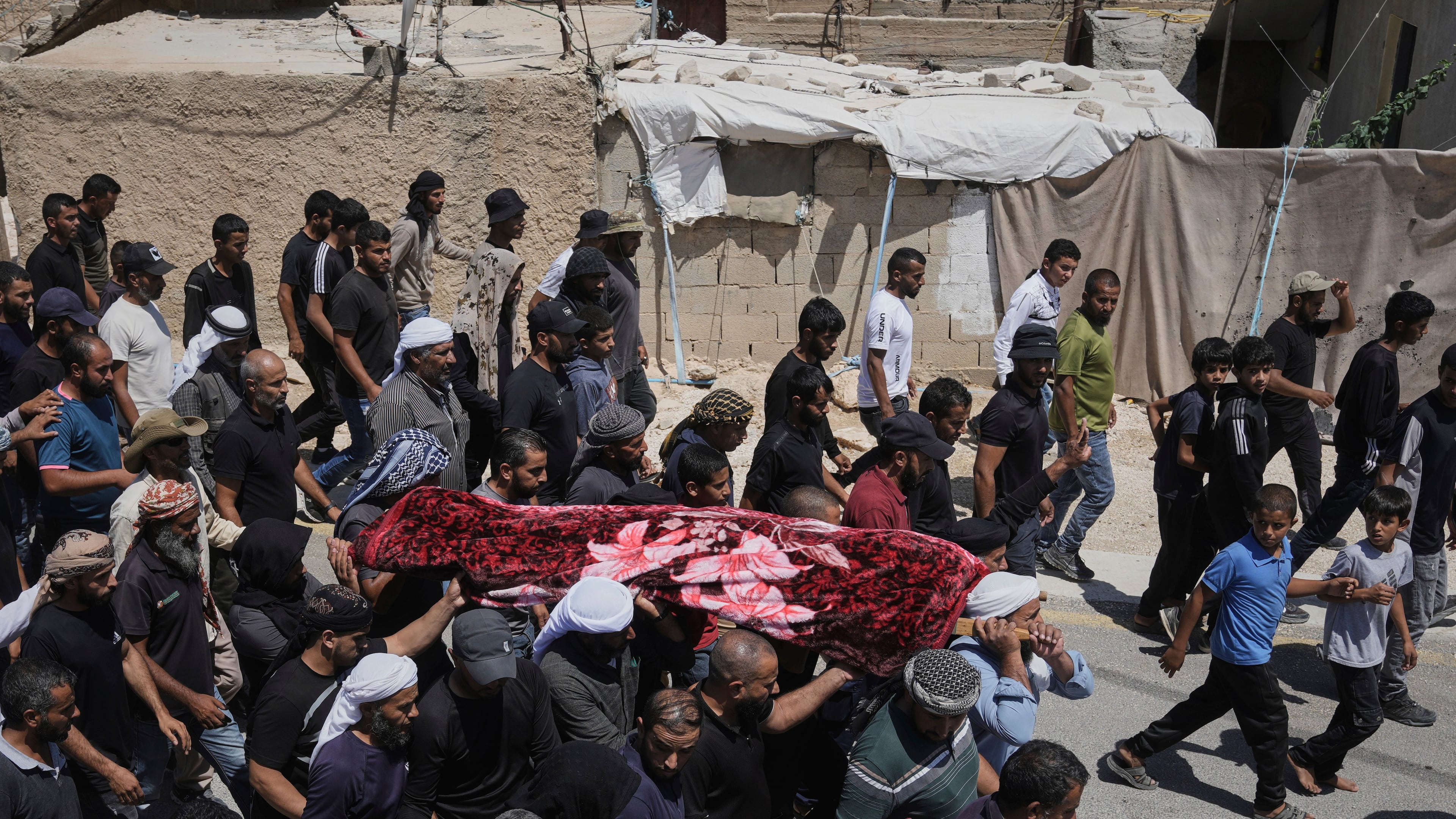 FILE -Mourners carry the body of Palestinian activist Awdah Al Hathaleen, who was killed by Israeli settler according to Palestinian health officials, during his funeral in the West Bank Bedouin village of Umm al-Khair, Aug. 7, 2025. (AP Photo/Mahmoud Illean, File)