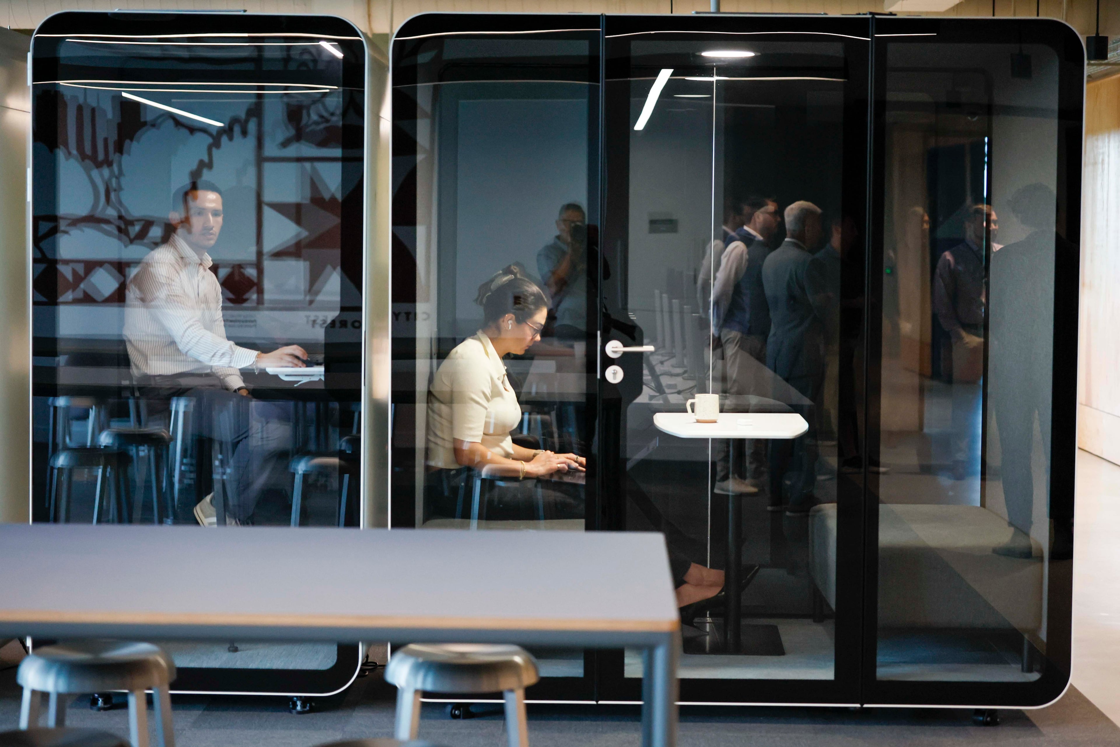 Rivian employees are seen working in private cubicles at the company's new East Coast headquarters in Atlanta. (Miguel Martinez/AJC)