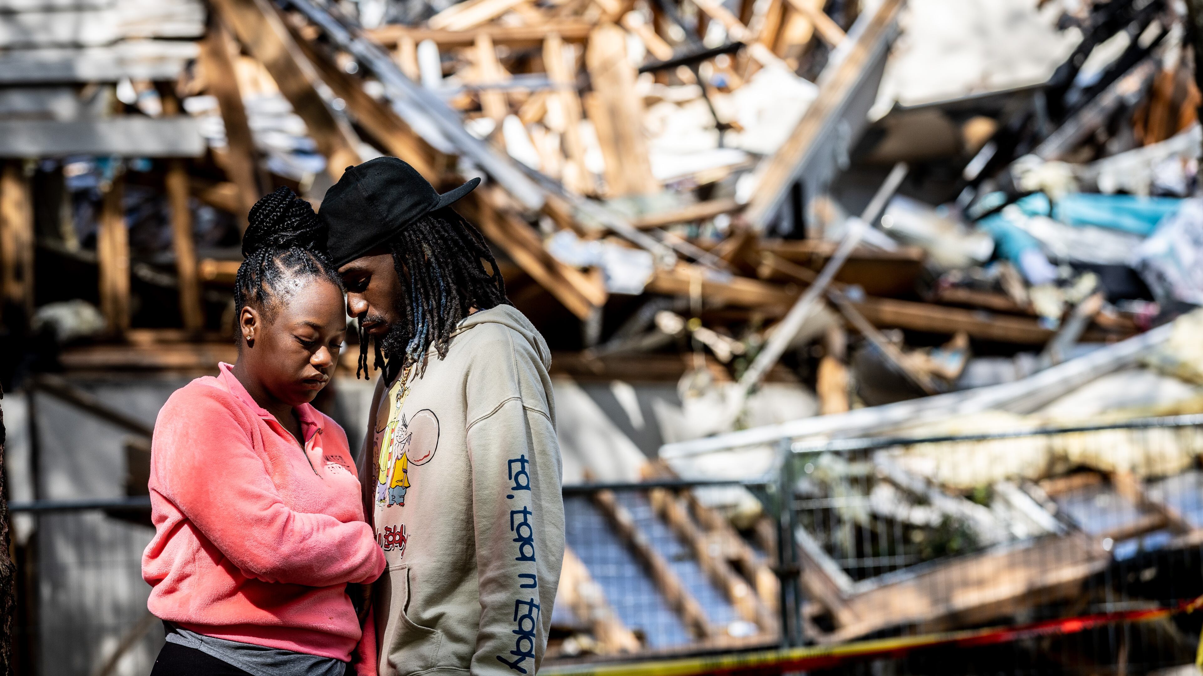 Destiny Raymond and Kris Hubbard stand in front of what is left of their Austell apartment Tuesday, April 25, 2023. (Steve Schaefer/steve.schaefer@ajc.com)