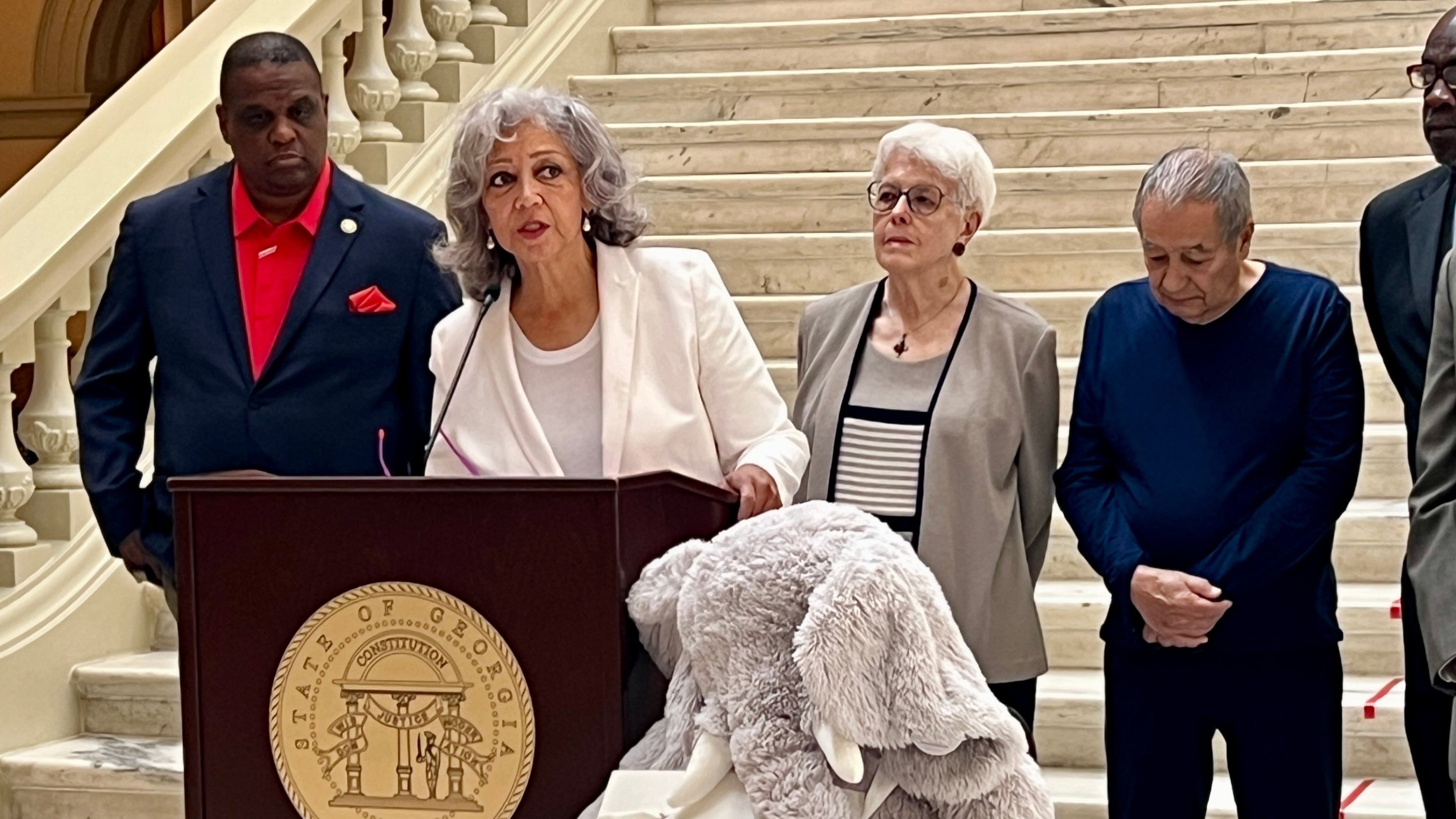 Georgia Federation of Teachers President Verdaillia Turner, at podium, is joined by past National Parent Teacher Association President Otha Thornton, to her left, lawmakers and retired educators at the Georgia Capitol on April 28, 2025. (Cassidy Alexander/AJC)