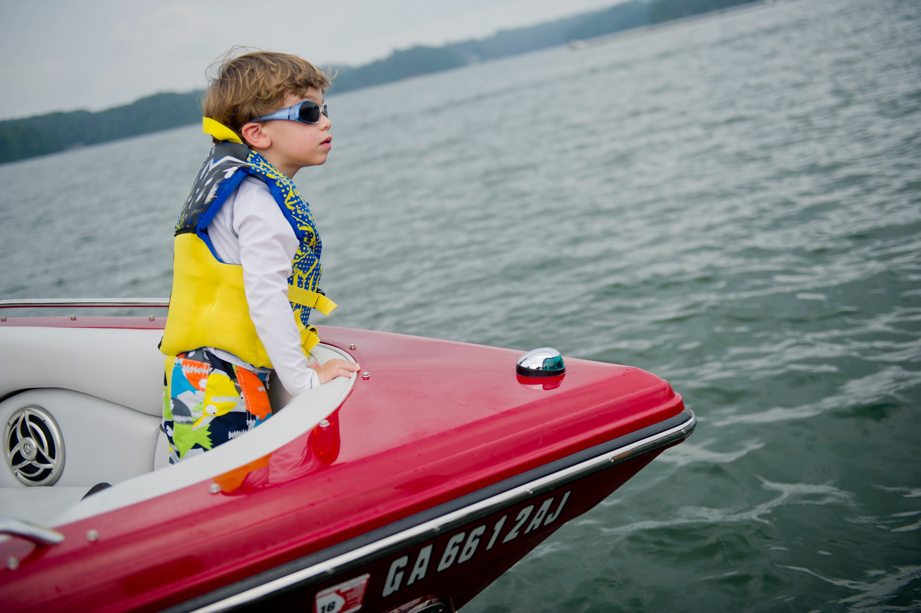 Jayden Cohen stands in the bow of his family's boat as they take a break from cruising on Lake Lanier in Gainesville on Sunday.