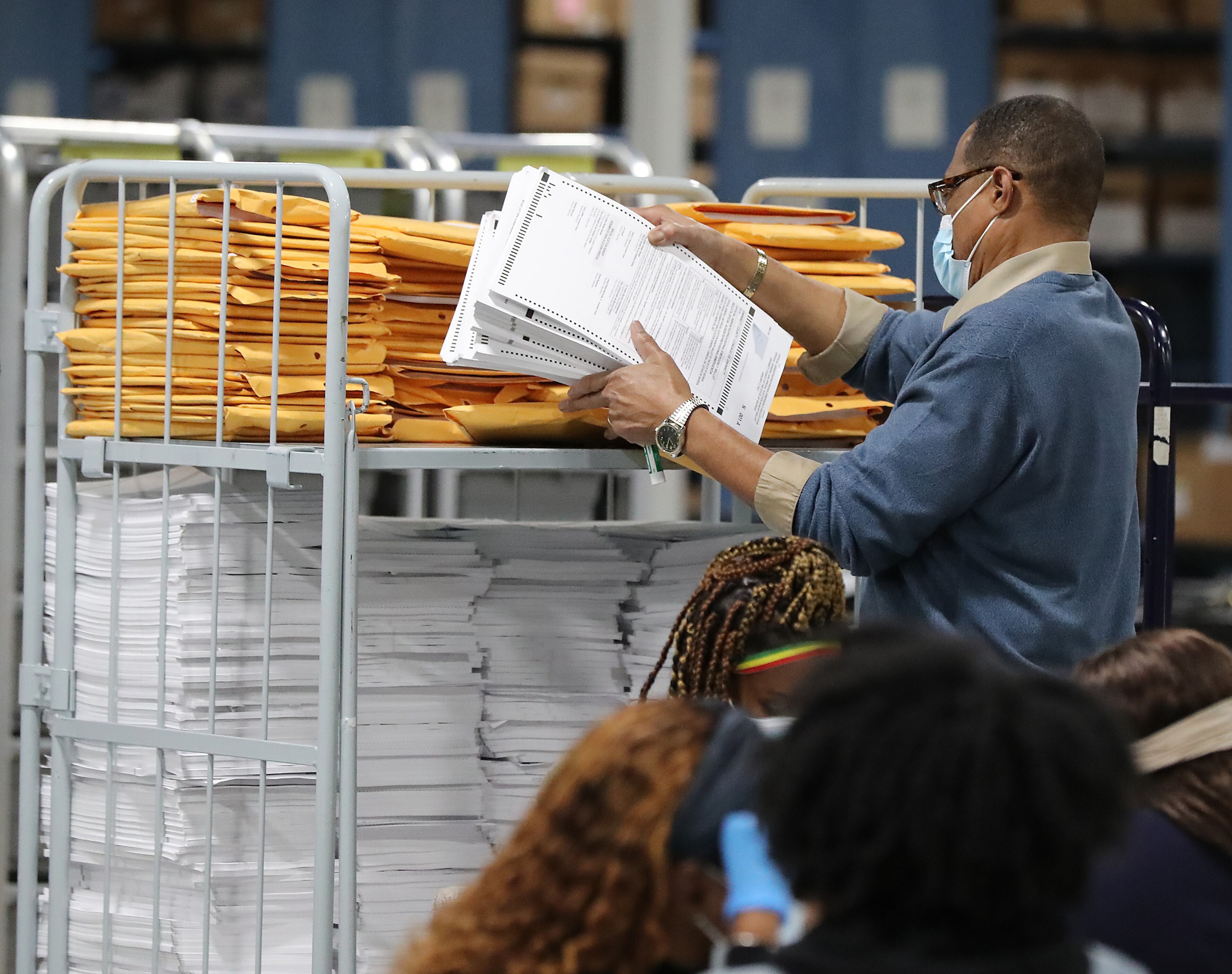 010521 LAWRENCEVILLE: An election worker sorts ballots at the Beauty P. Baldwin Voter Registrations and Elections Building on Tuesday night after the polls closed, Jan. 5, 2021, in Lawrenceville. Curtis Compton / Curtis.Compton@ajc.com”