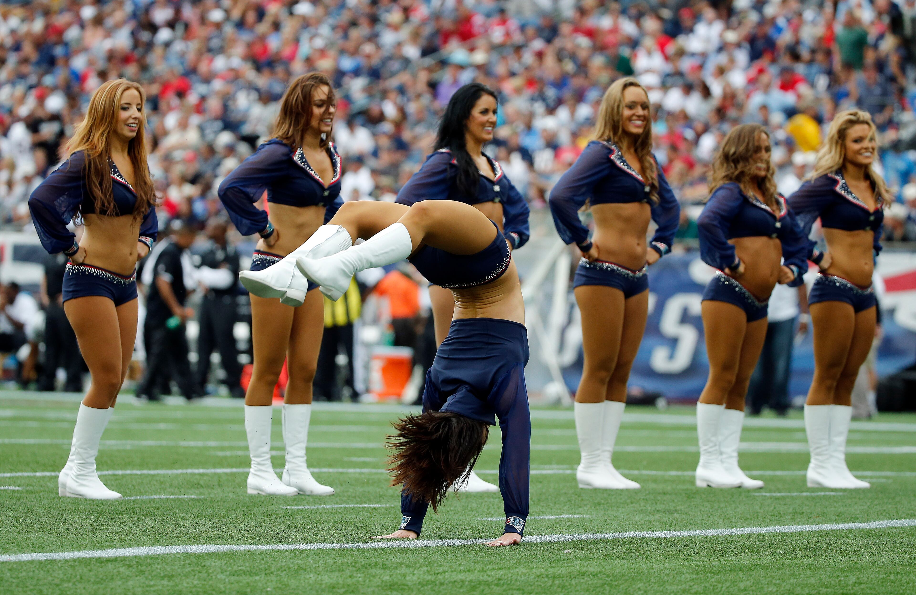 A New England Patriots cheerleader flips across the field in the first half of an NFL football game between the Patriots and the Oakland Raiders Sunday, Sept. 21, 2014, in Foxborough, Mass. (AP Photo/Elise Amendola)