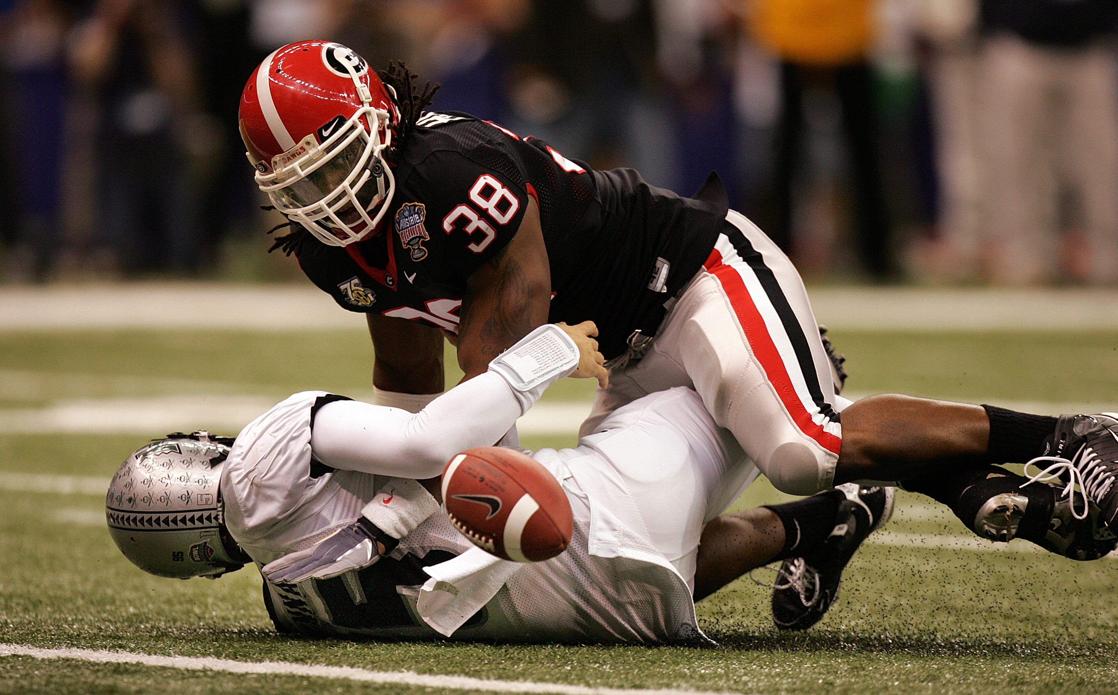 Georgia defensive end Marcus Howard (38) hits Hawaii quarterback Colt Brennan (15) hard enough to cause the fumble and recovers for a touchdown in the Sugar Bowl on Jan. 1, 2008 in New Orleans. BRANT SANDERLIN / Staff