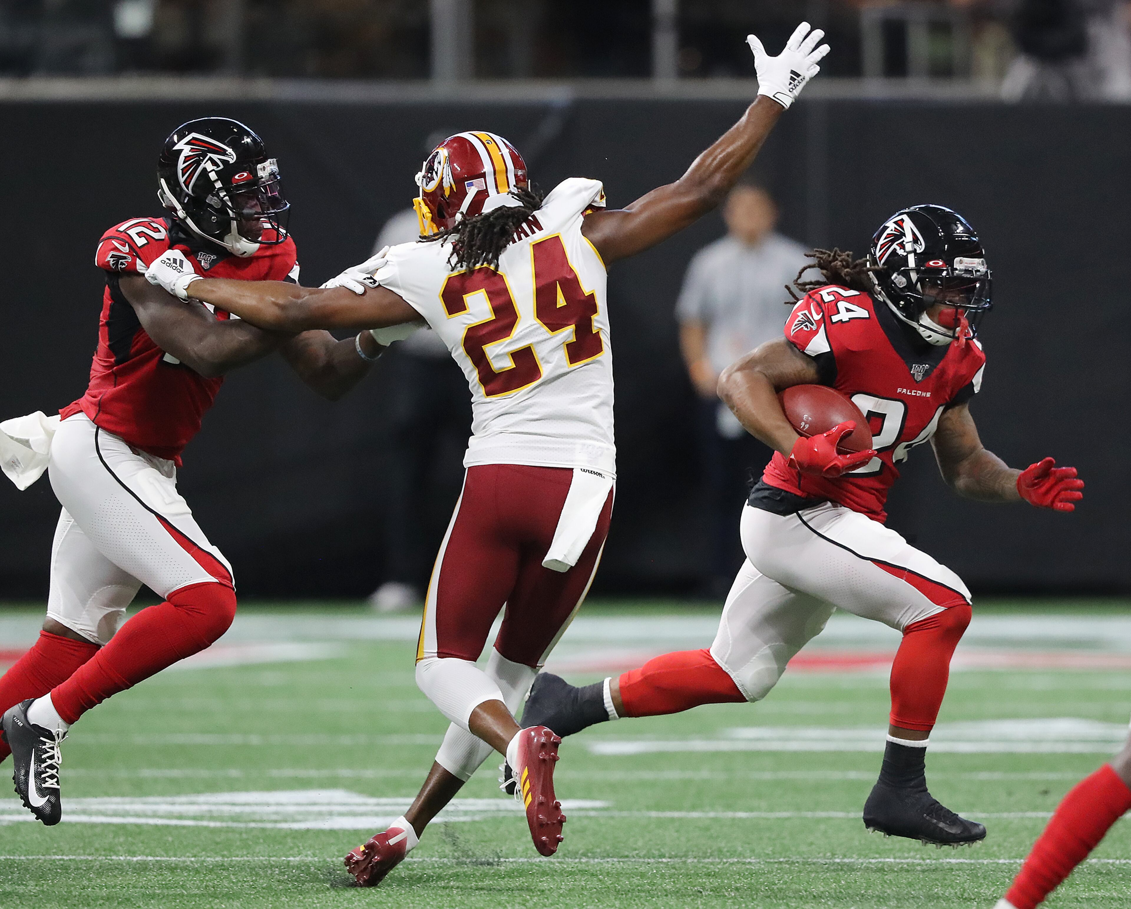 Falcons running back Devonta Freeman picks up yardage against the Washington Redskins with a block from Mohamed Sanu. Curtis Compton/ccompton@ajc.com
