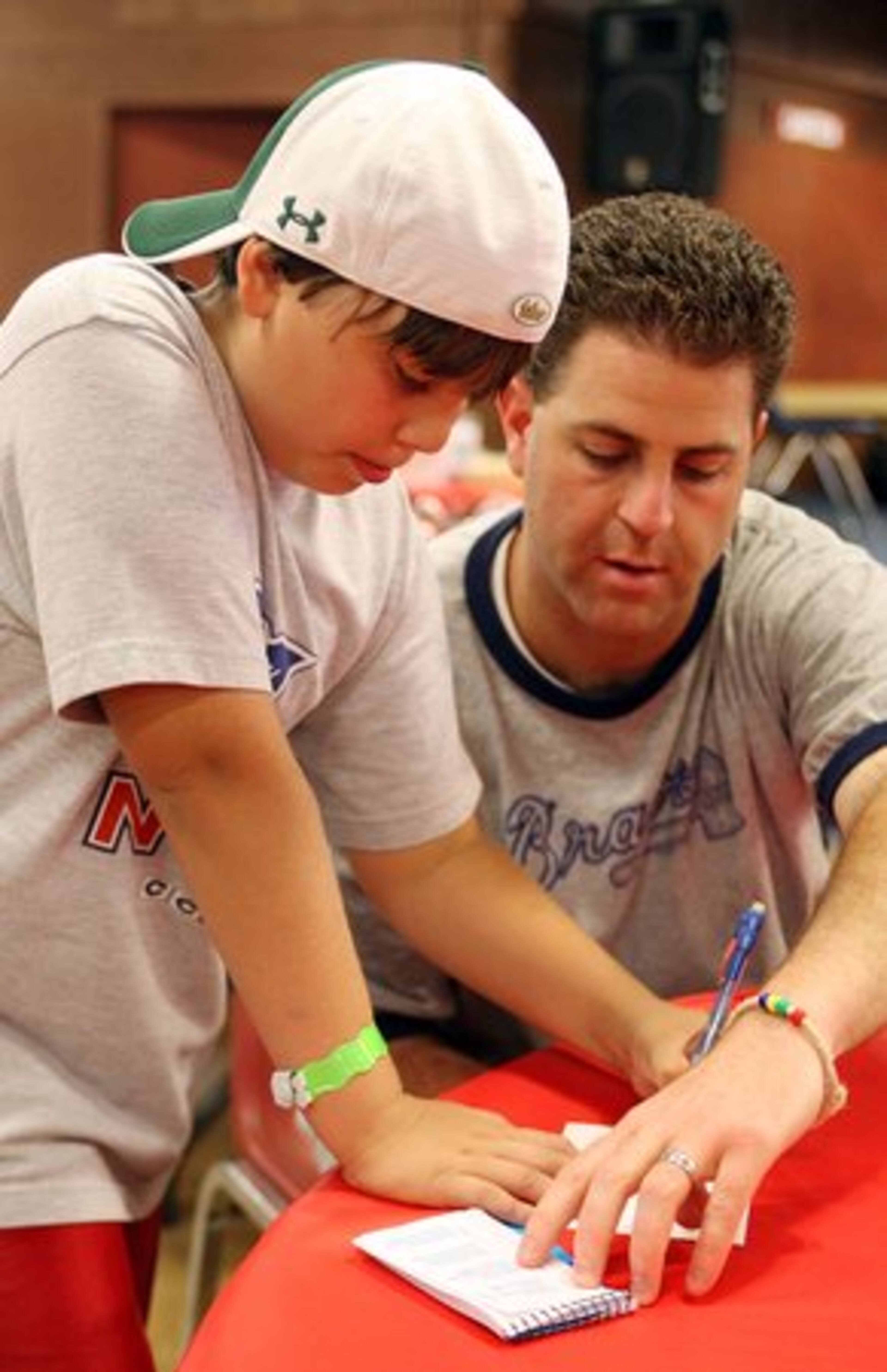 Brad Cohen (right) helps Dylan Zurita fill out a postcard.