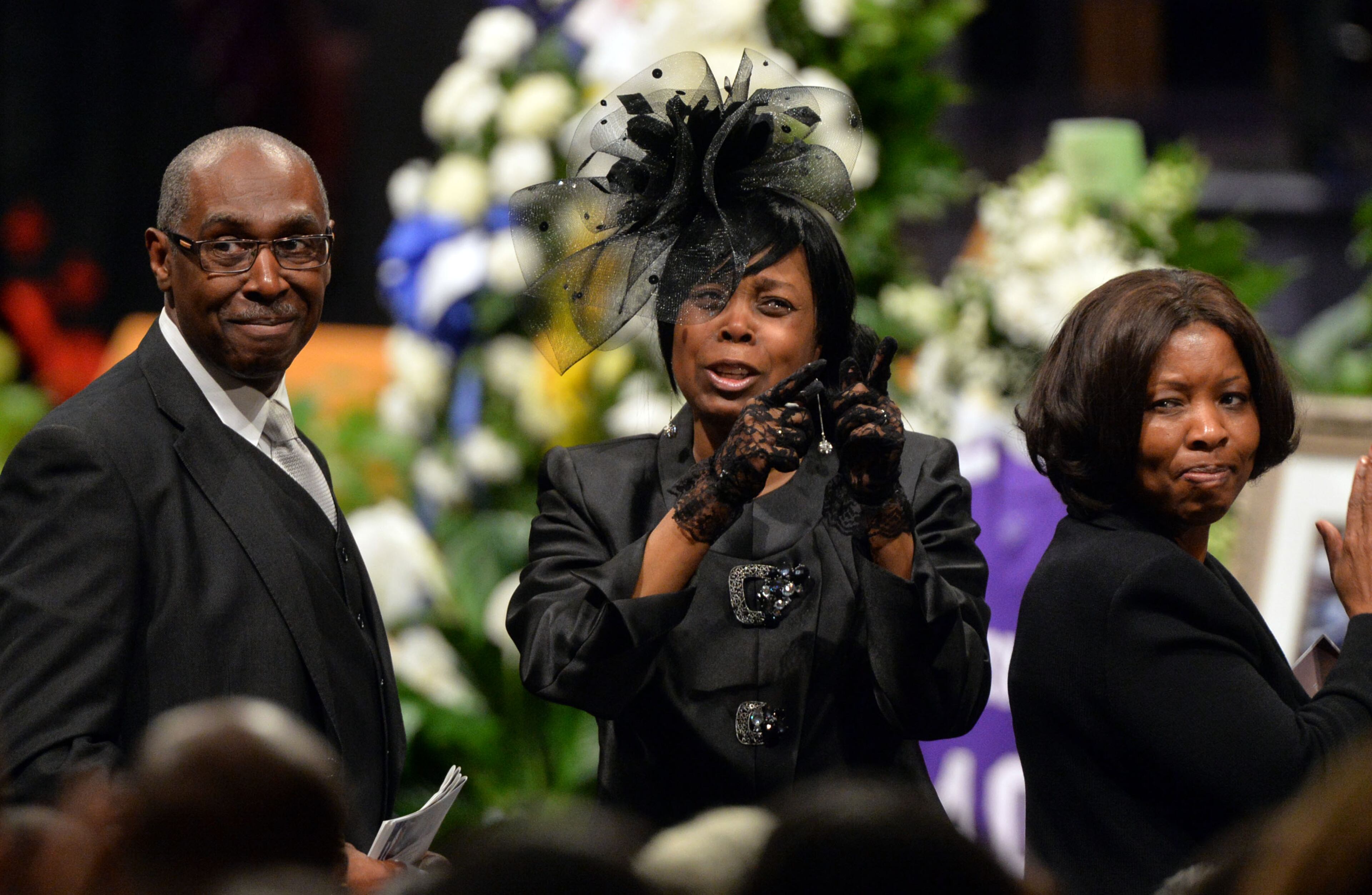 APRIL 18, 2014 ATLANTA Jermaine Hall's mother, Debbie Faulkner (center) celebrates his life with her husband Arvester and Hall's mother-in-law, Brenda Strickland during the service. Atlanta Fire Rescue officials and firefighters joined with family and friends during the funeral of AFRD firefighter Jermaine Hall at New Birth Missionary Baptist Church, Friday, April 18, 2014. Firefighter Hall, 24, died as the result of a brain aneurysm. He was the second AFRD firefighter to die in the last week. Memorial funds for both Hall and Sgt Frank Guinn, who was killed in an accident in New Orleans, have been set up at Wells Fargo branches. Donations can be made to any Wells Fargo branch in the names of Frank Guinn Memorial Fund Jermaine Hall Memorial Fund. KENT D. JOHNSON/KDJOHNSON@AJC.COM