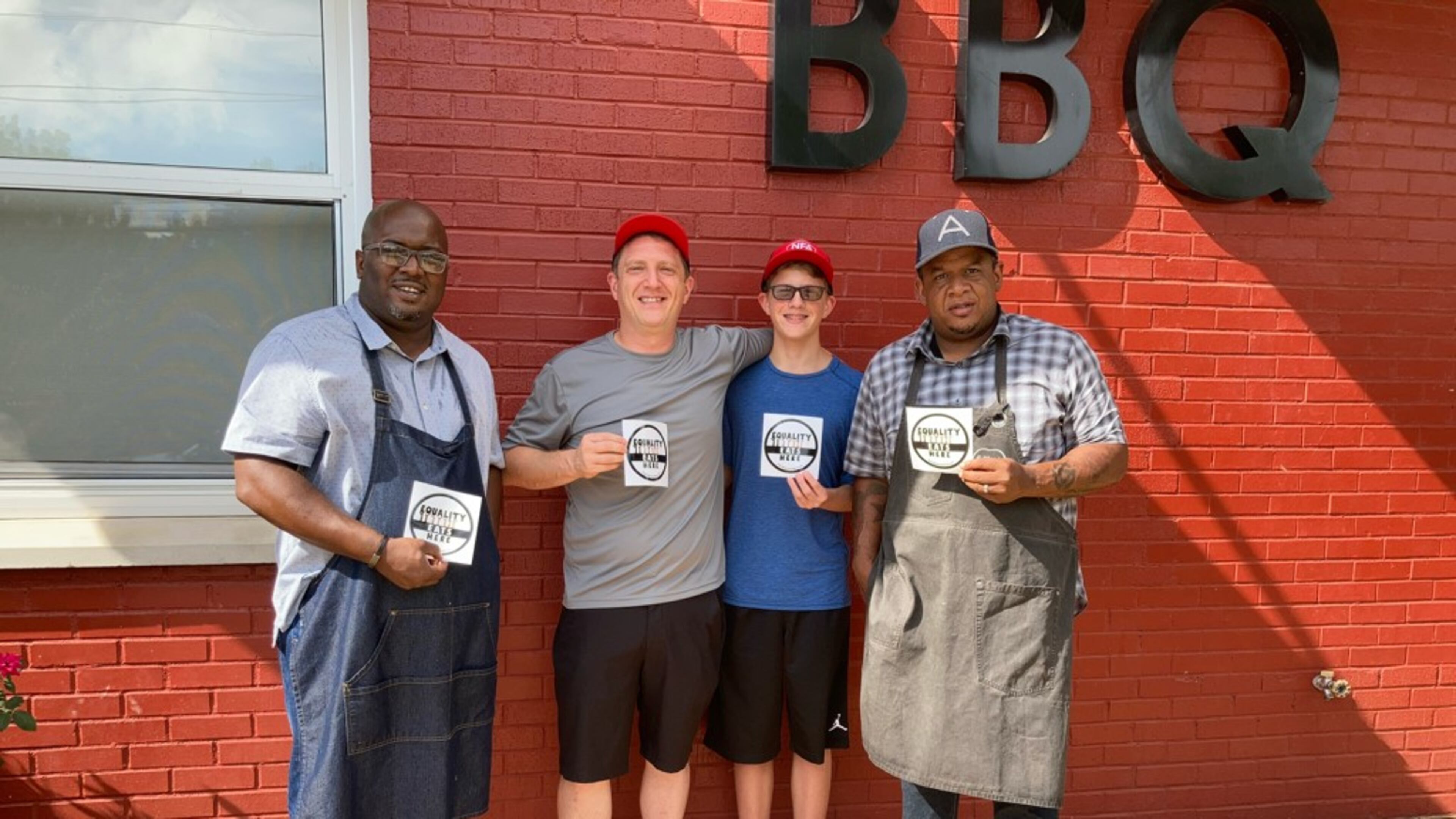 Equality Lives Here founder and NFA Burger Billy Kramer (second from left) with Lake & Oak BBQ owners Josh Lee (far left) and Todd Richards (far right). / Courtesy of Equality Lives Here