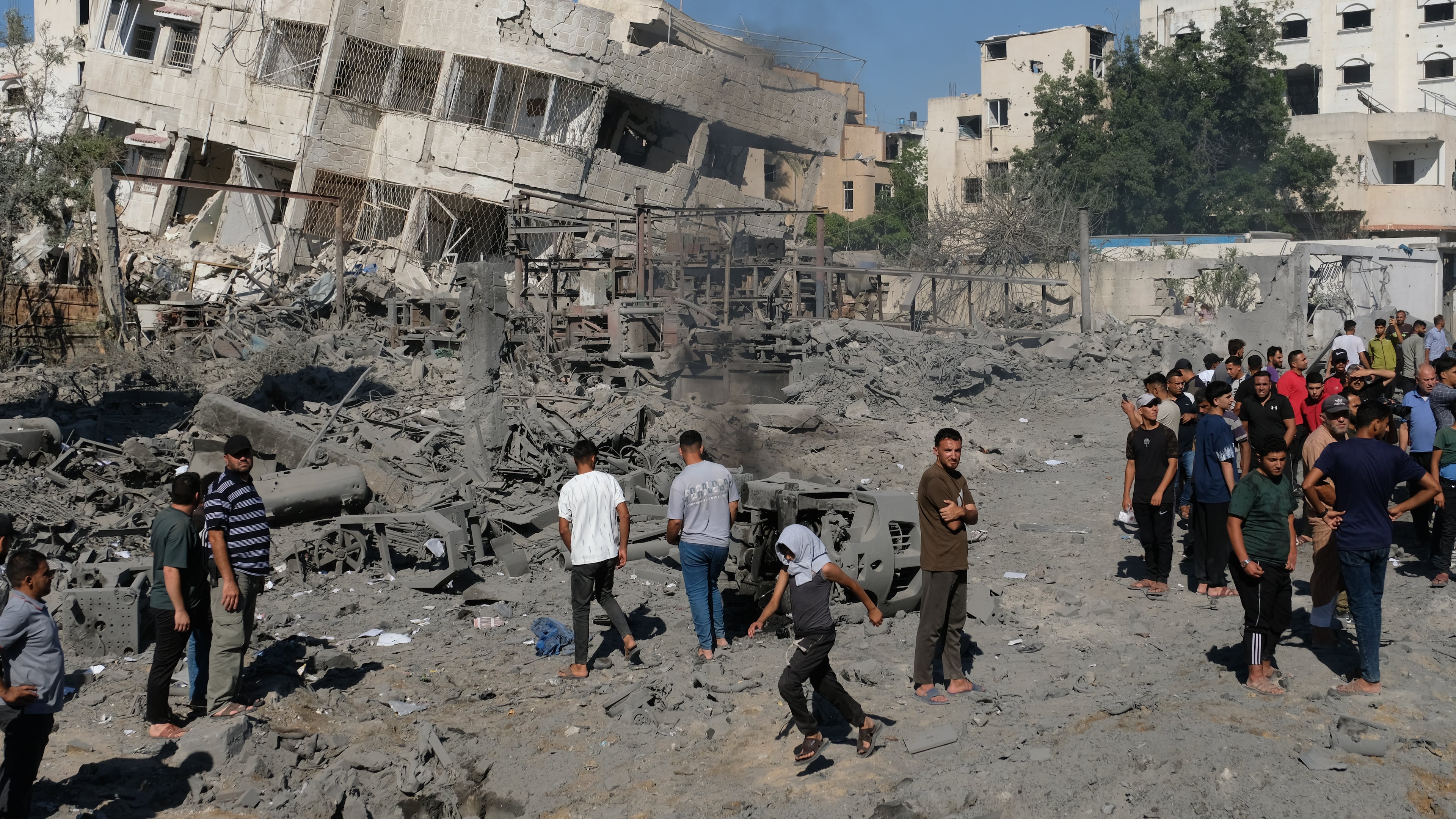 Palestinians gather around the site of an Israeli military drone strike on a blacksmith shop in Gaza City's Sabra neighborhood killing at least four Palestinians and wounded another, according to officials at Shifa hospital, where the casualties were taken on Sunday, July 12, 2026. (AP Photo/Jehad Alshrafi)