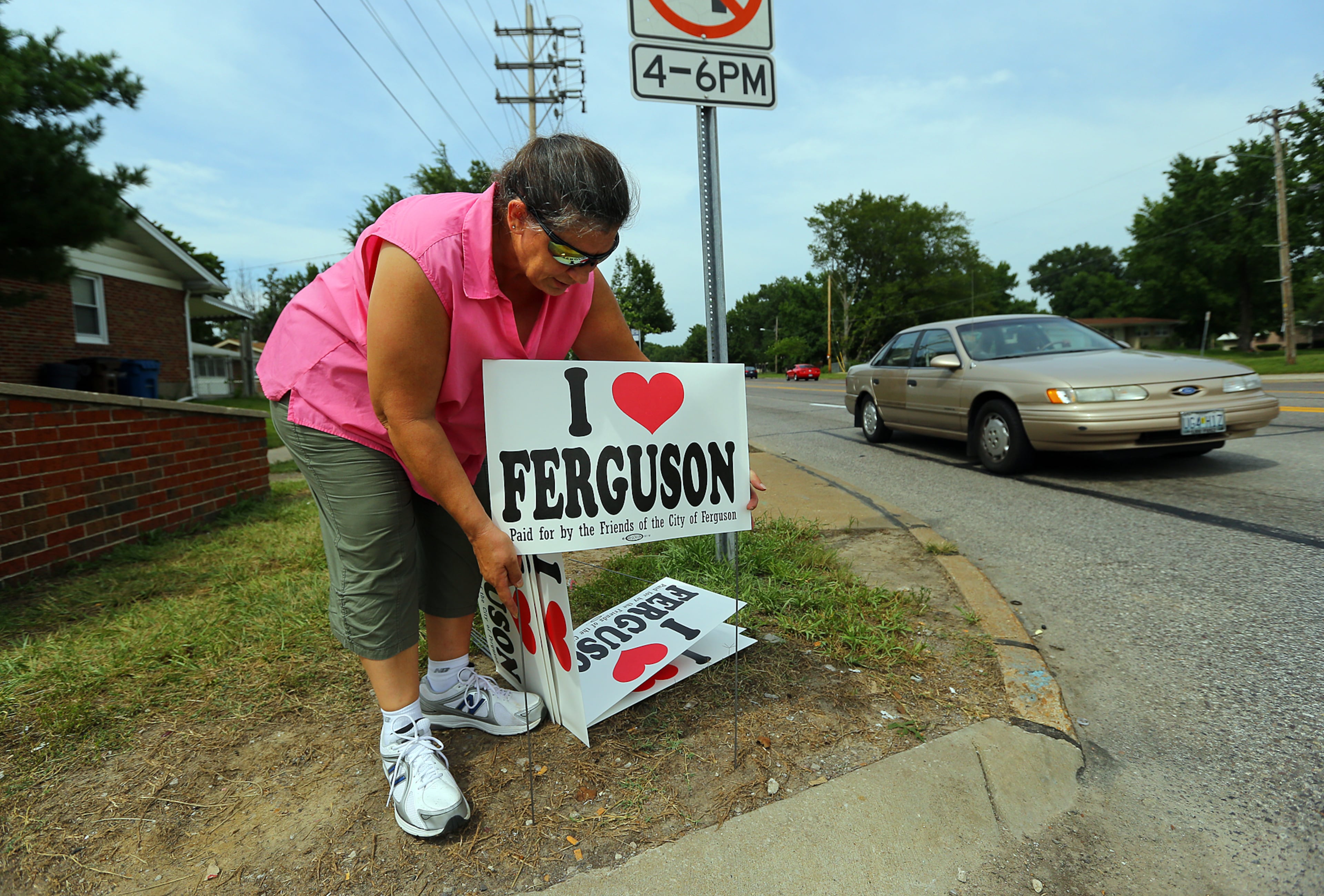 Rainey Wilson, who lives in Ferguson, sets out signs along West Florissant Avenue on Wednesday, Aug. 20, 2014, in Ferguson. Wilson said "we love Ferguson and want everyone to know it's not a bad place." CURTIS COMPTON / CCOMPTON@AJC.COM
