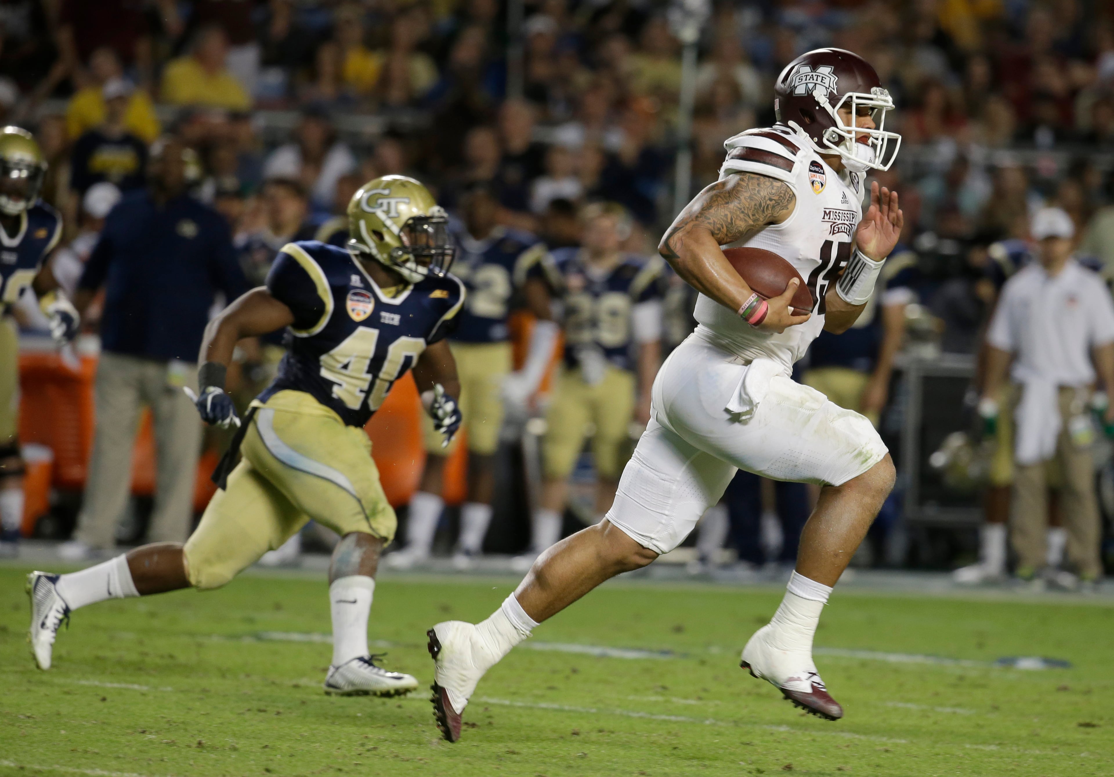 Mississippi State quarterback Dak Prescott, right, runs for a first down as Georgia Tech linebacker Paul Davis (40) pursues in the first half of the Orange Bowl NCAA college football game, Wednesday, Dec. 31, 2014, in Miami Gardens, Fla. (AP Photo/Lynne Sladky)