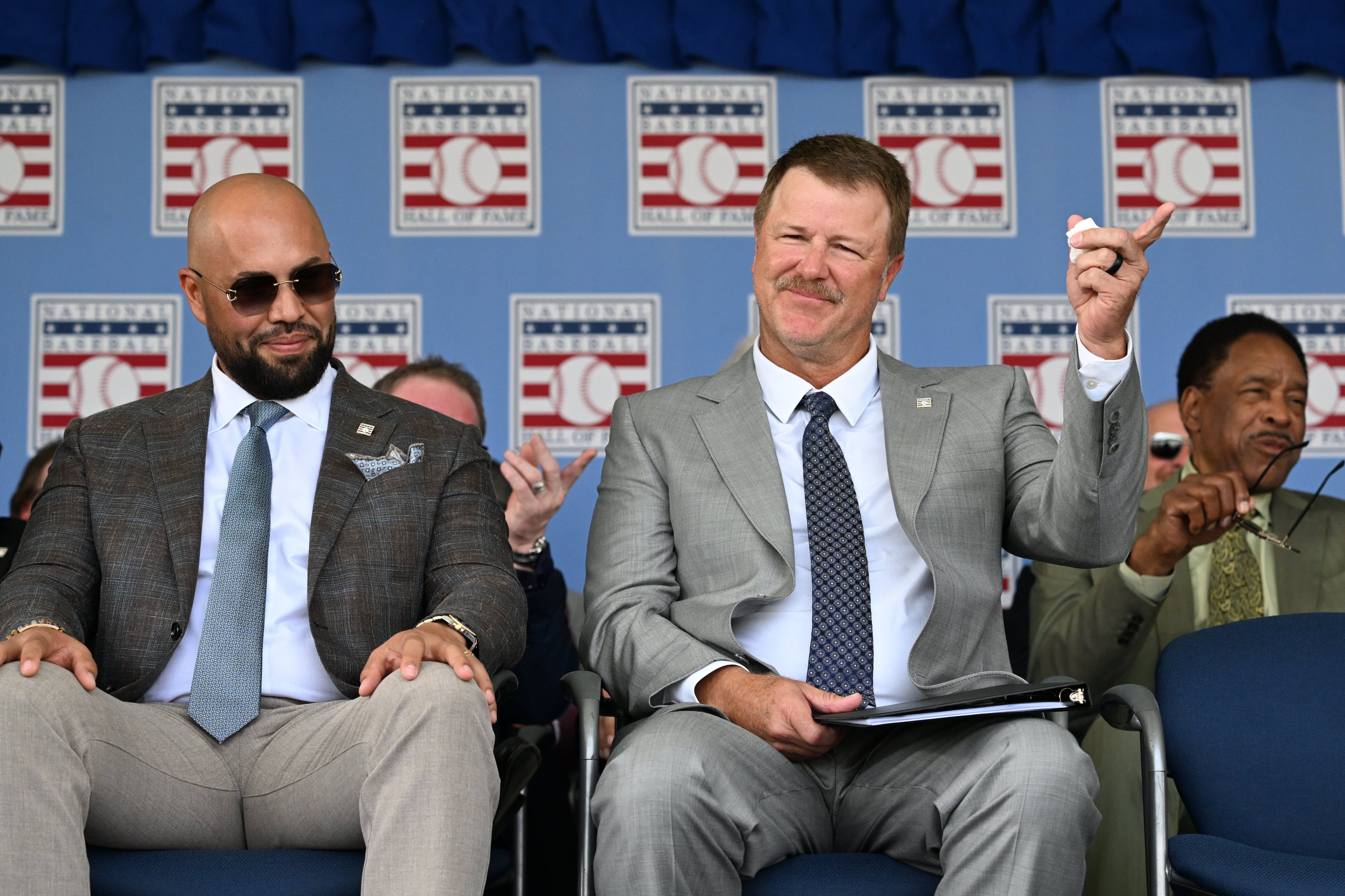 Jeff Kent, right, reacts as he sits next to Carlos Beltrán before he is inducted into Baseball Hall of Fame during the 2026 National Baseball Hall of Fame Induction Ceremony at the Clark Sports Center on Sunday, July 26, 2026, in Cooperstown, N.Y. Braves centerfielder Andruw Jones is set for induction into the National Baseball Hall of Fame as part of the Class of 2026, alongside Carlos Beltrán and Jeff Kent. (Hyosub Shin/AJC)